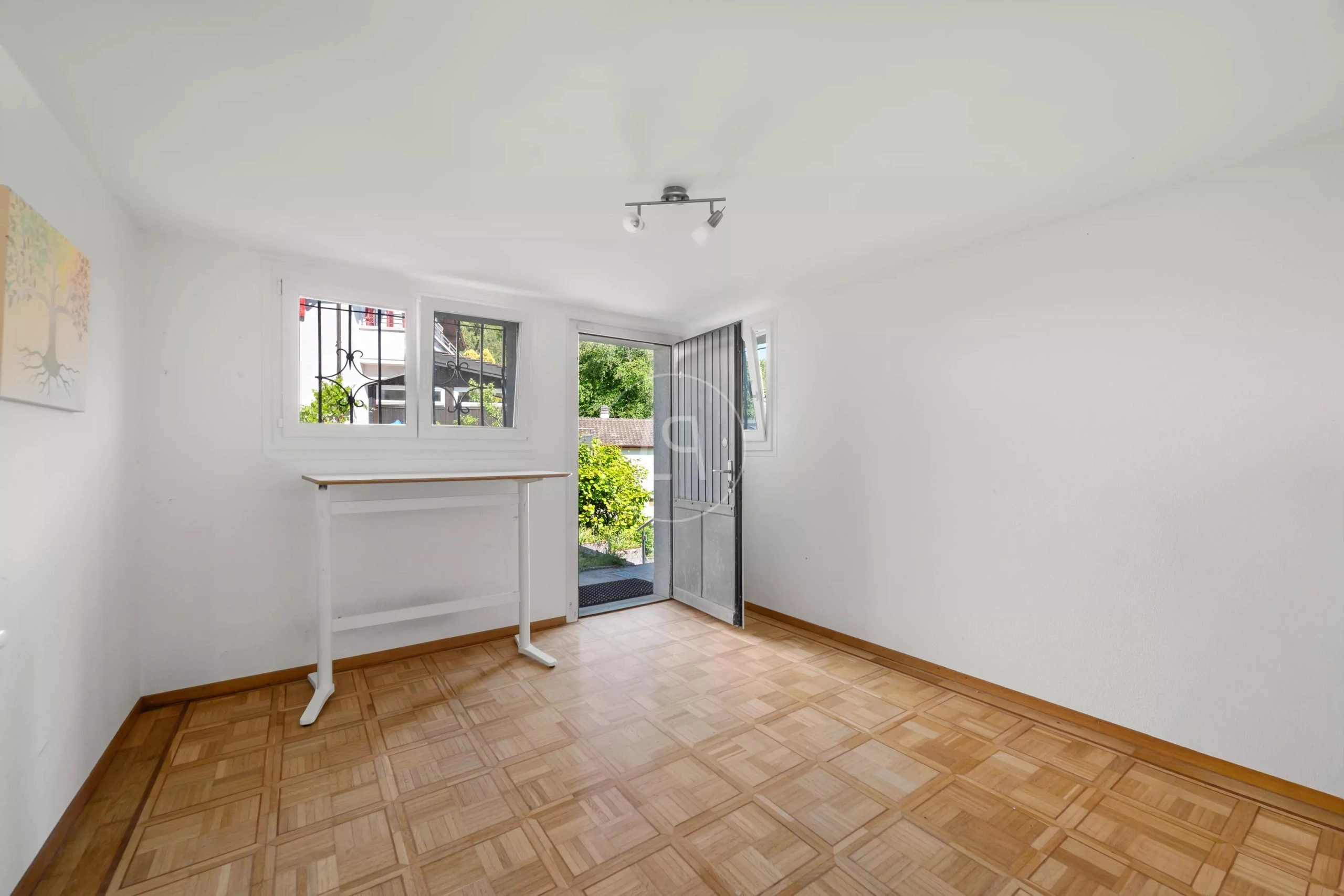 Heller leerer Raum mit offenem Eingang und Fensterfront