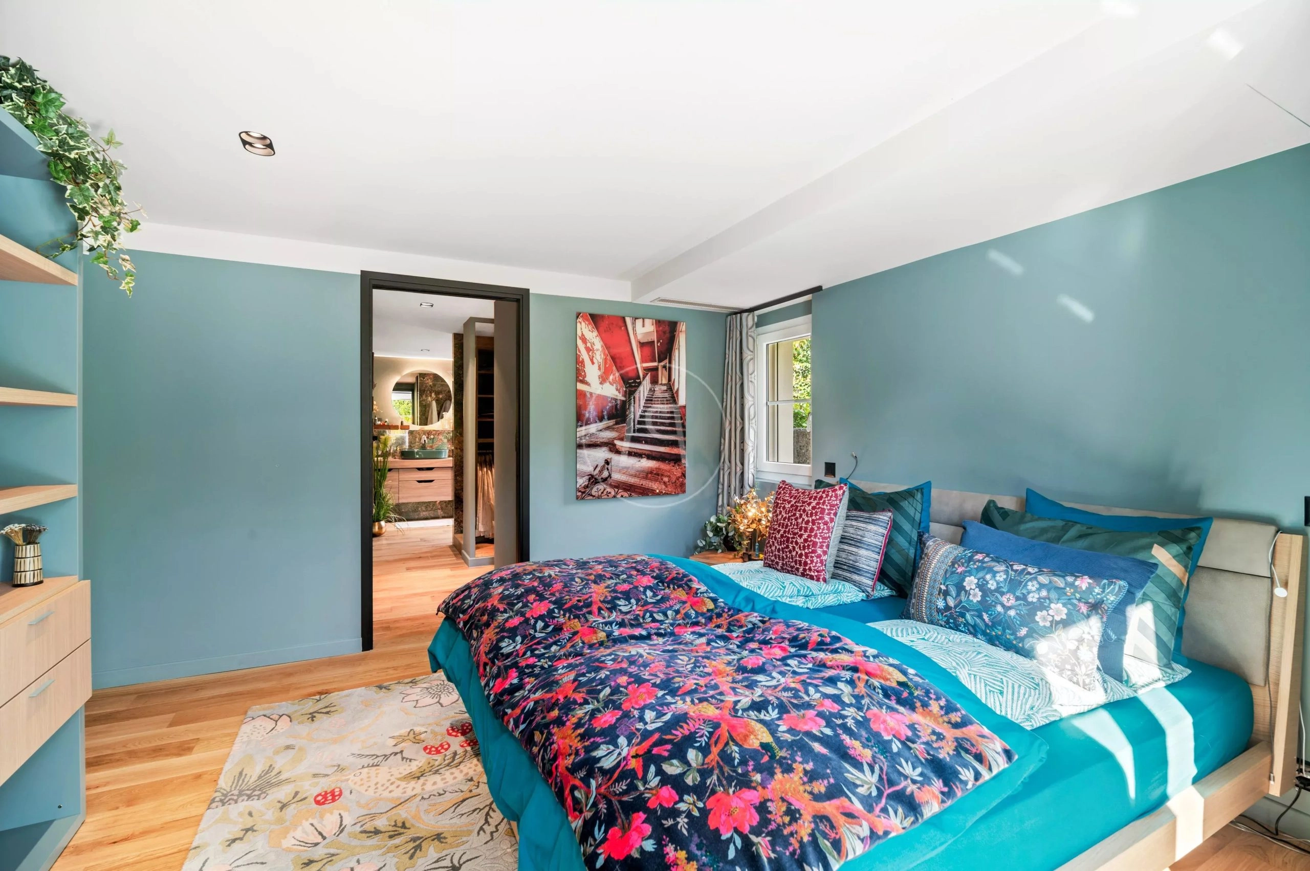 Bunt eingerichtetes Schlafzimmer mit blaugrünen Wänden