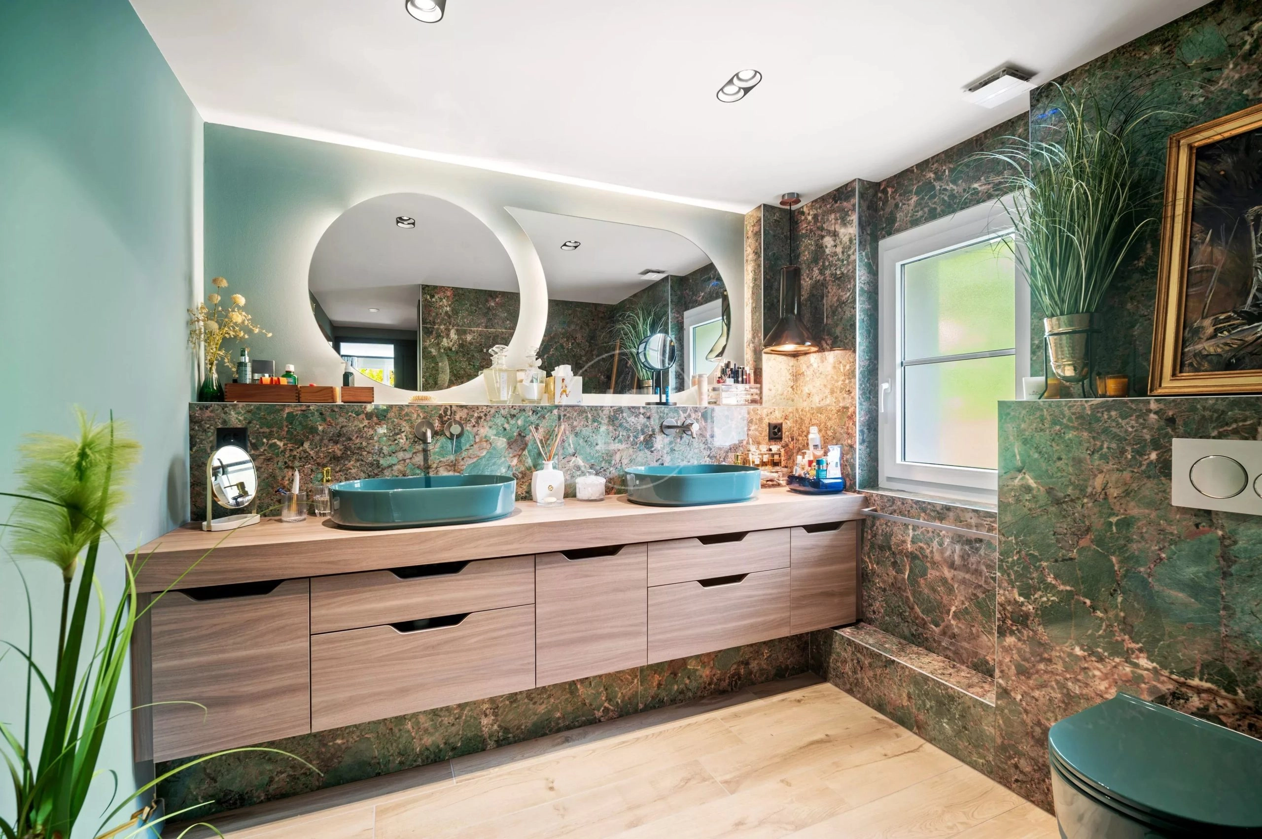 Luxuriöses Badezimmer mit grünen Natursteinflächen und Doppelwaschtisch