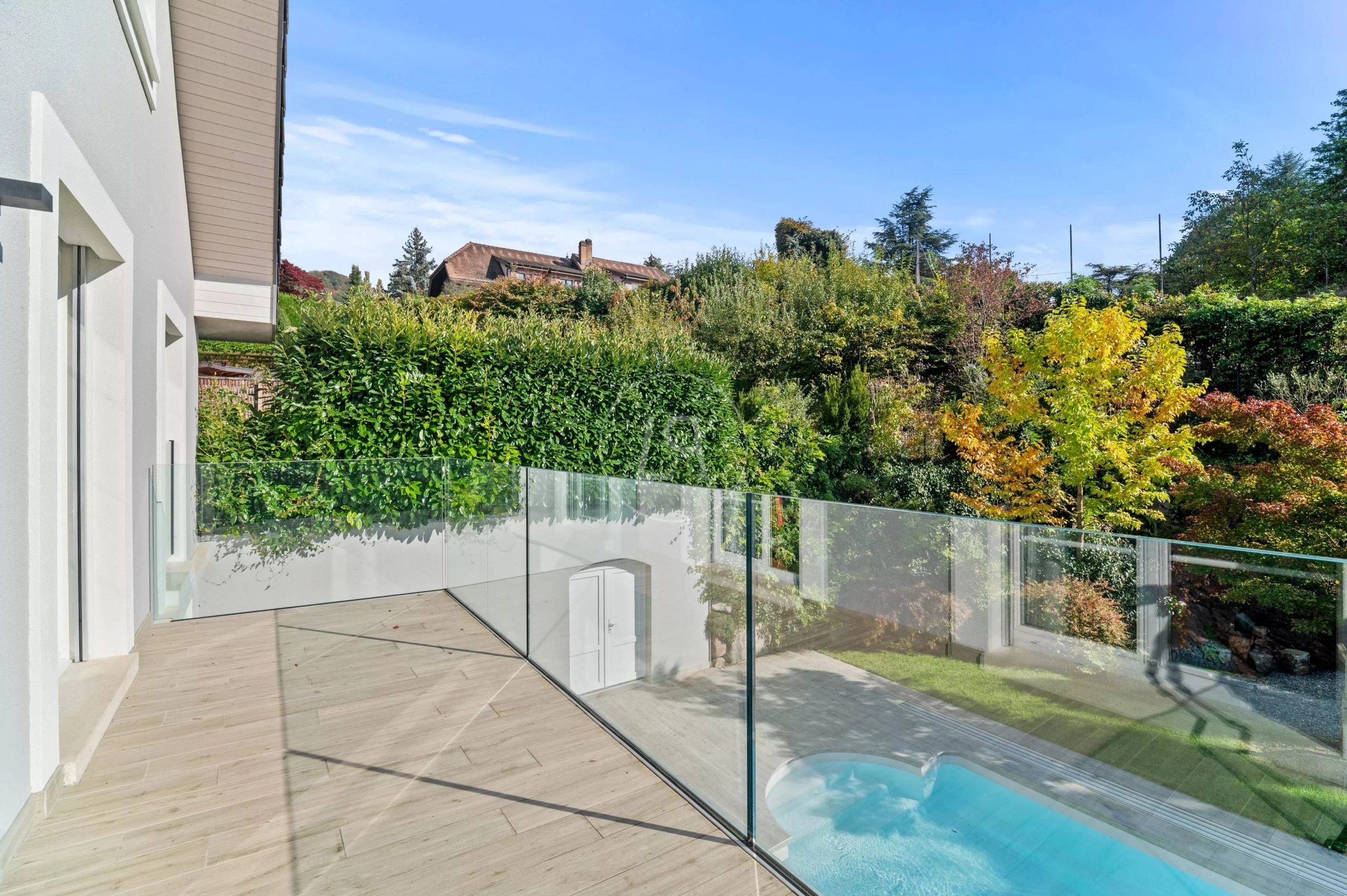 Balkon mit Glasgeländer und Gartenblick