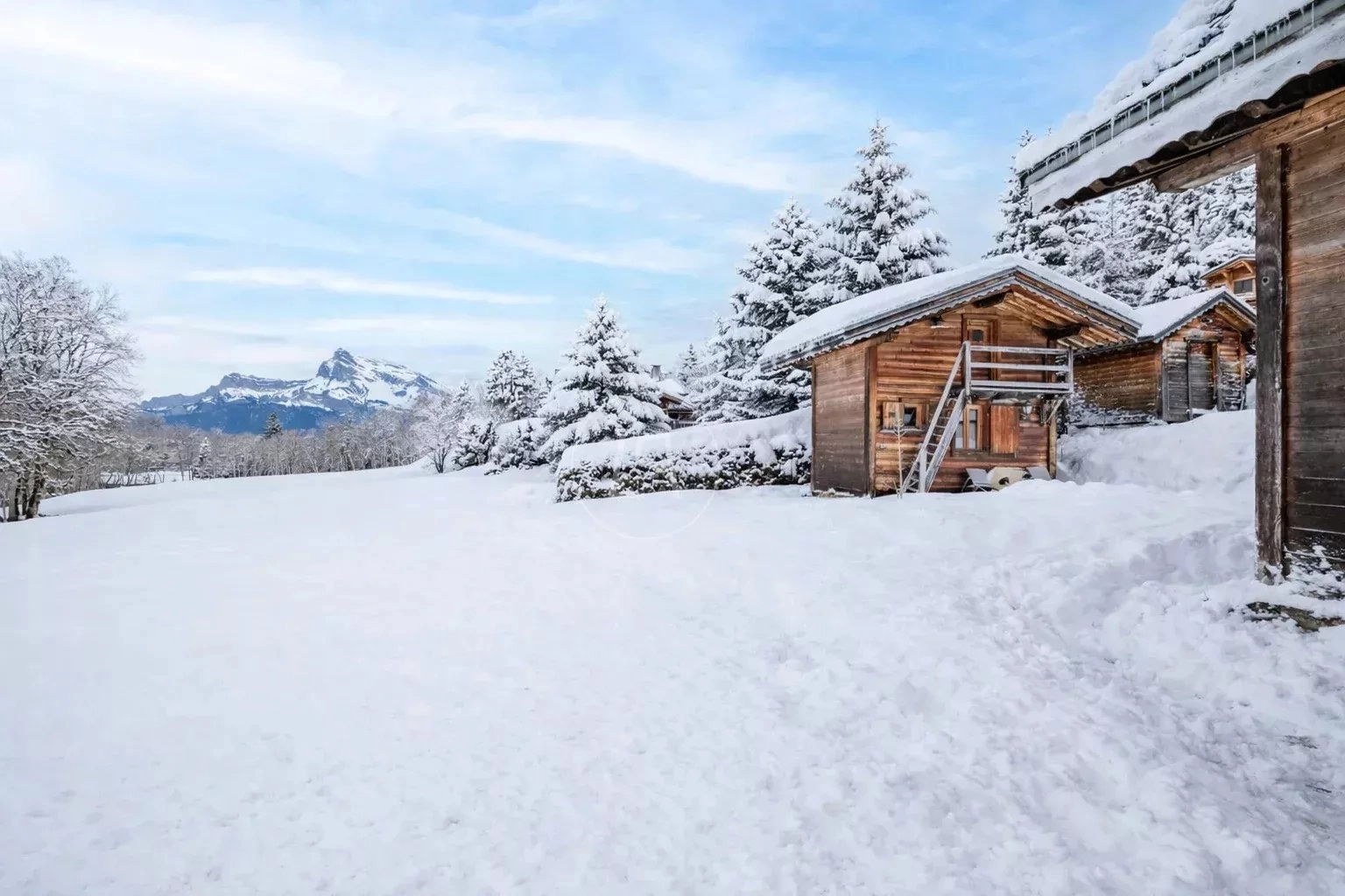 Verschneite Almhütte mit Bergblick