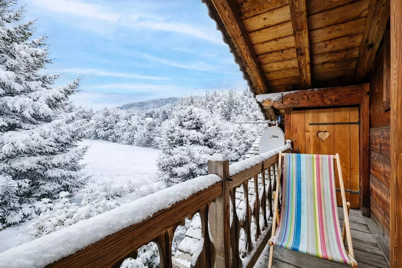 Verschneiter Holzbalkon mit Bergblick