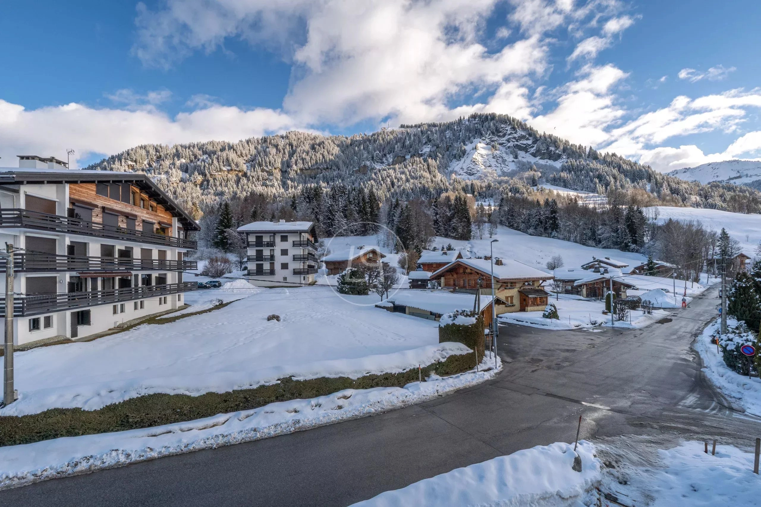 Schneelandschaft mit Alpenpanorama und Wohnbebauung