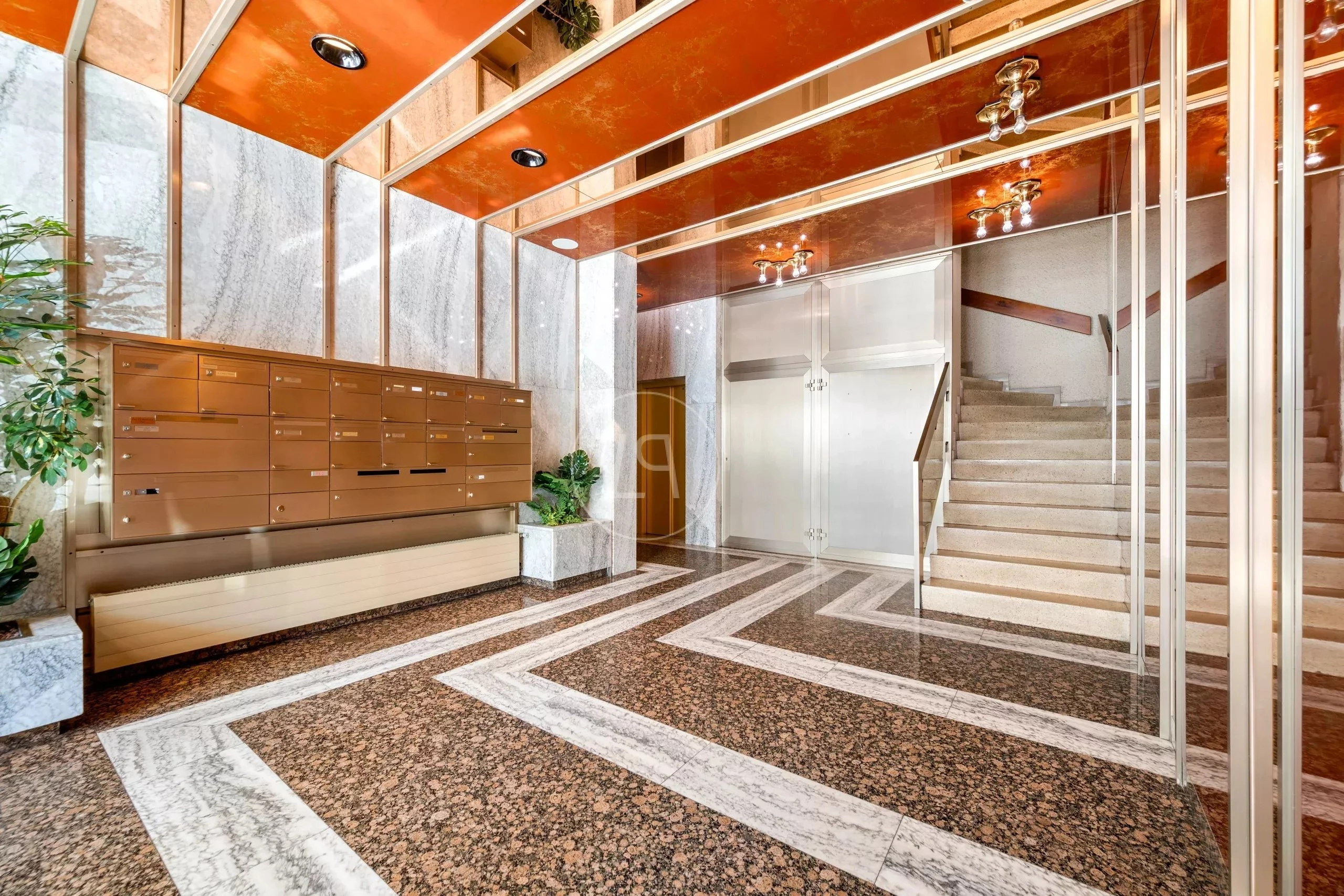 Eleganter Eingangsbereich mit Treppe und Briefkastenanlage