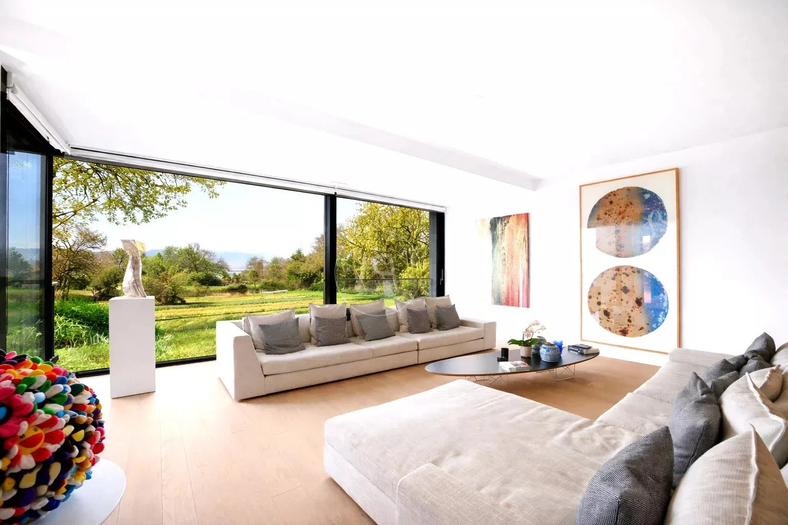 Helles Wohnzimmer mit Panoramafenster und Kunst