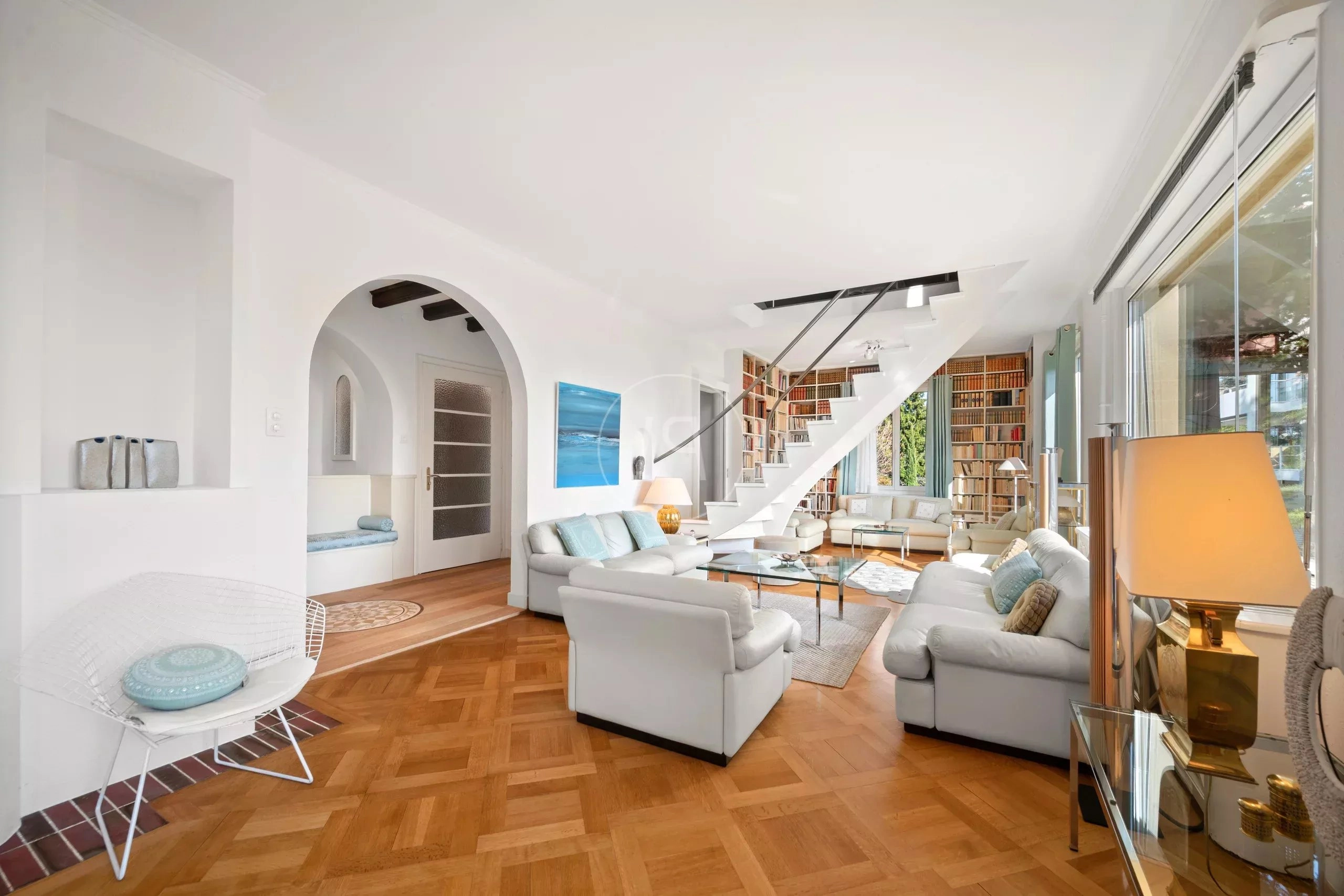 Heller Wohnraum mit Treppe und Bibliothekswand