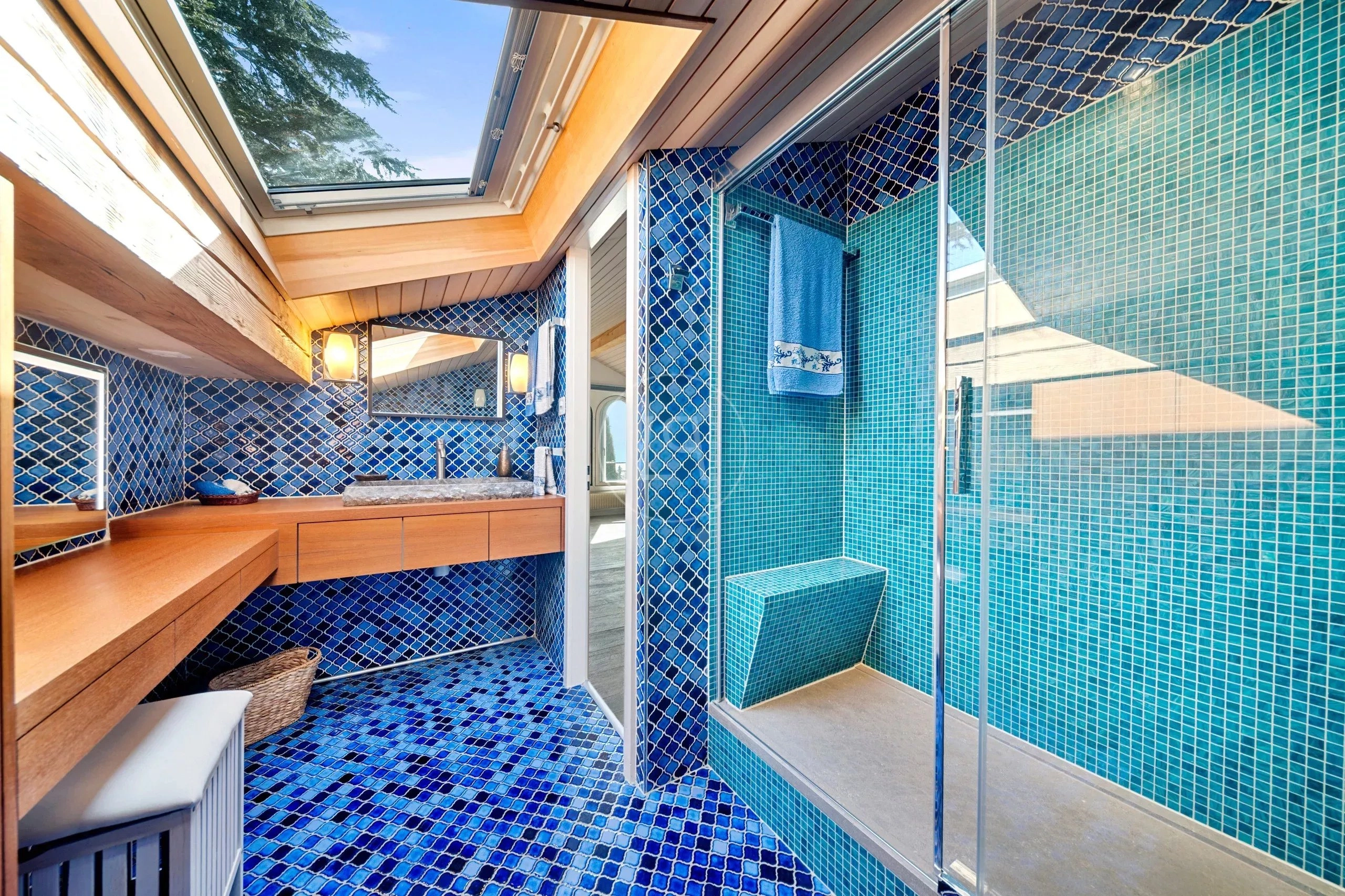 Badezimmer mit blauen Mosaikfliesen und Dachfenster