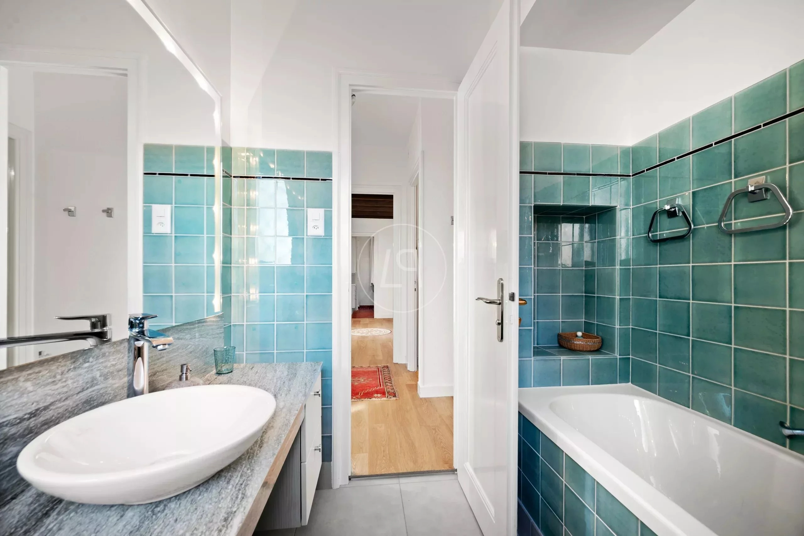 Badezimmer mit türkisfarbenen Fliesen und Badewanne