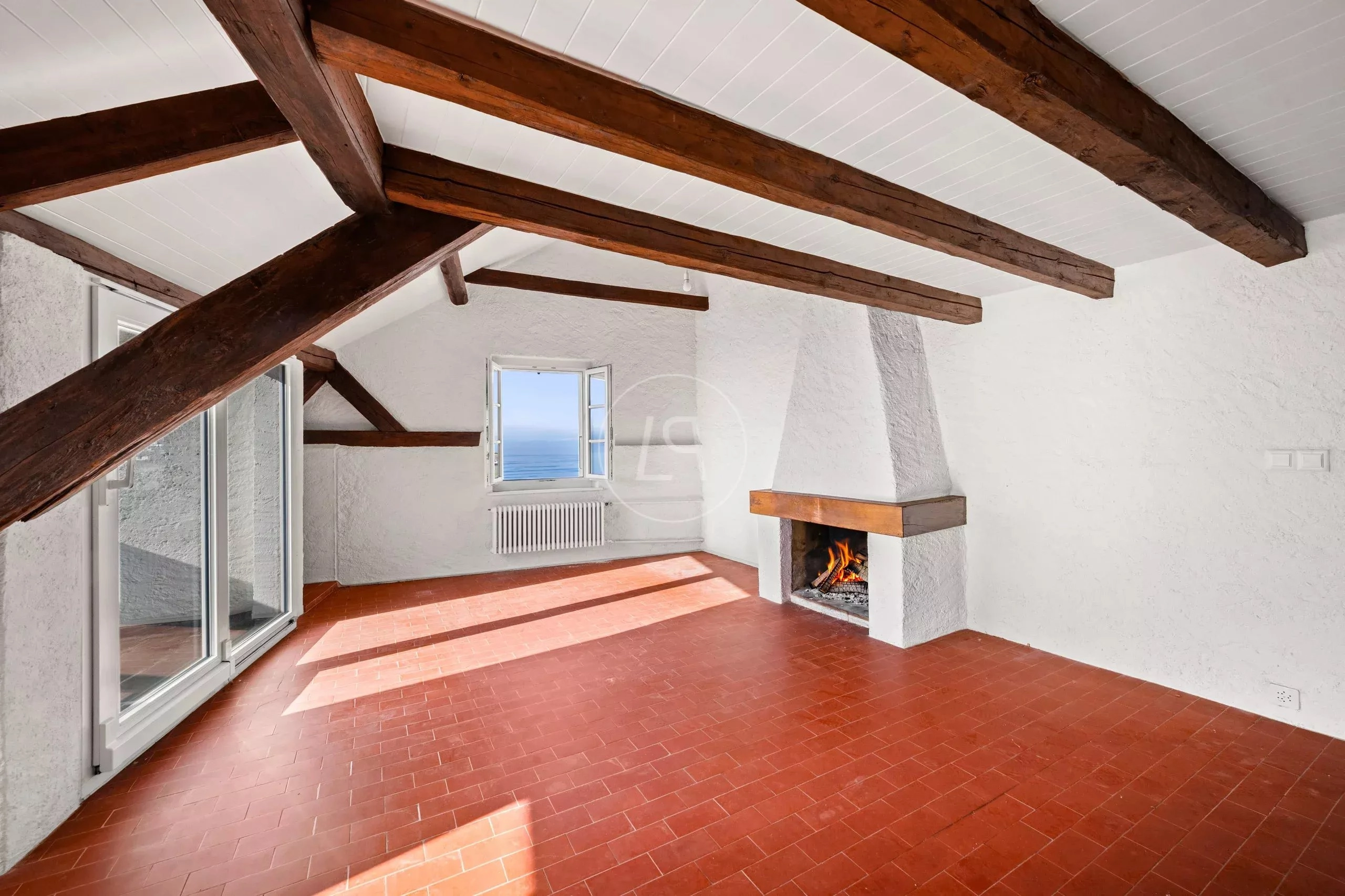 Wohnraum mit sichtbaren Holzbalken und Kamin