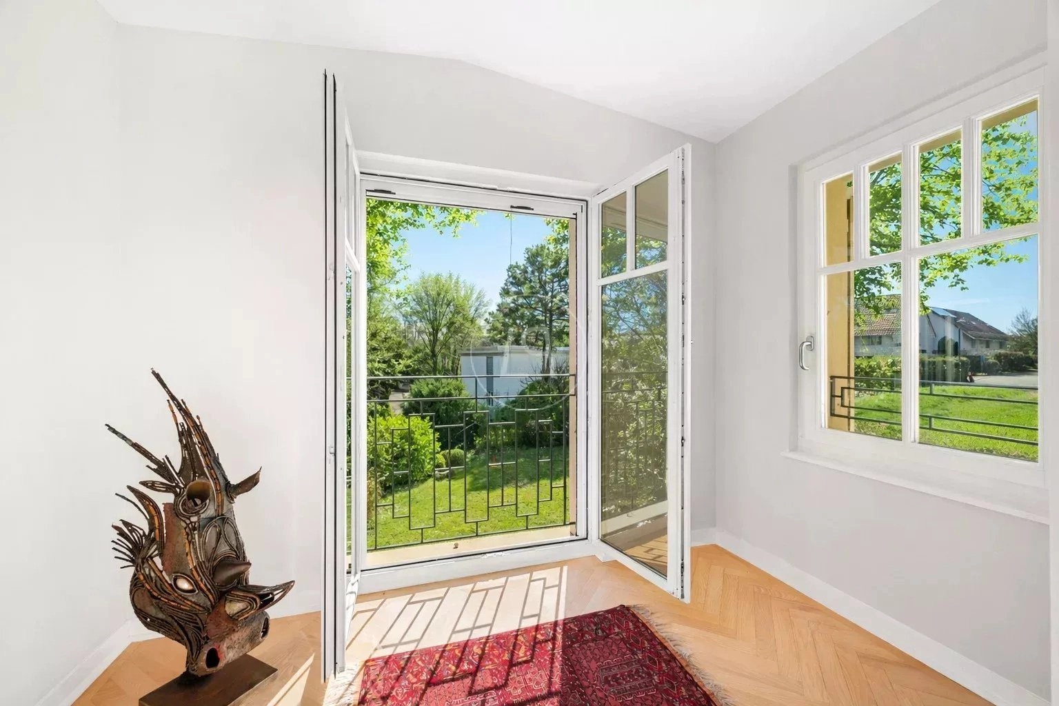 Heller Raum mit Balkon- bzw. Terrassentür und Gartenblick
