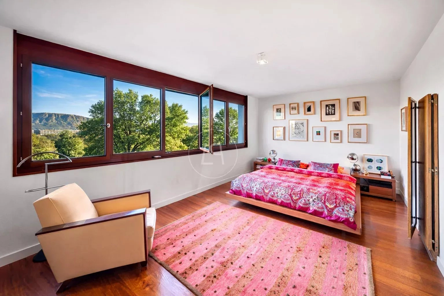 Helles Schlafzimmer mit großem Fenster und Blick ins Grüne