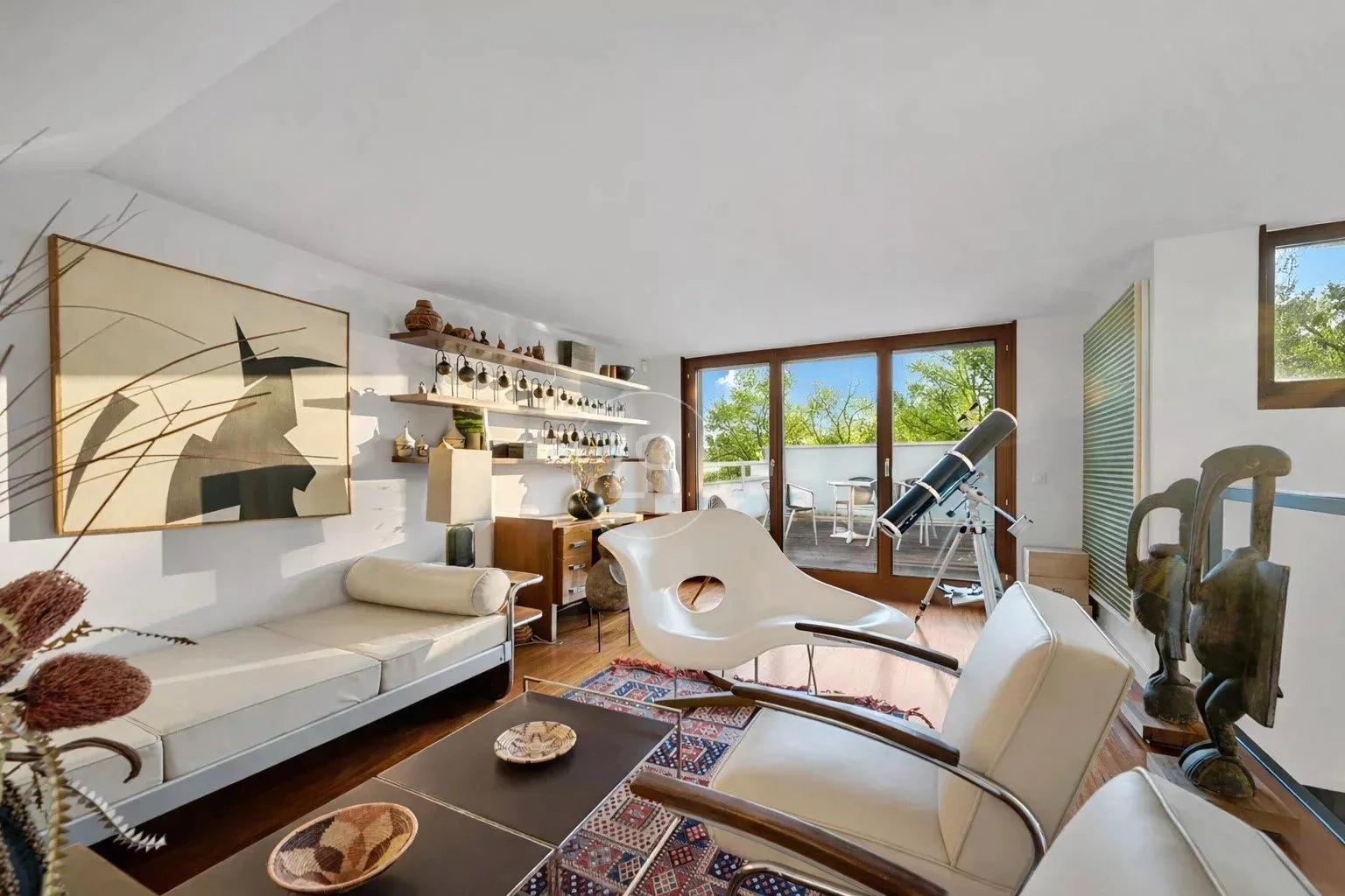 Hell eingerichtetes Wohnzimmer mit Terrasse