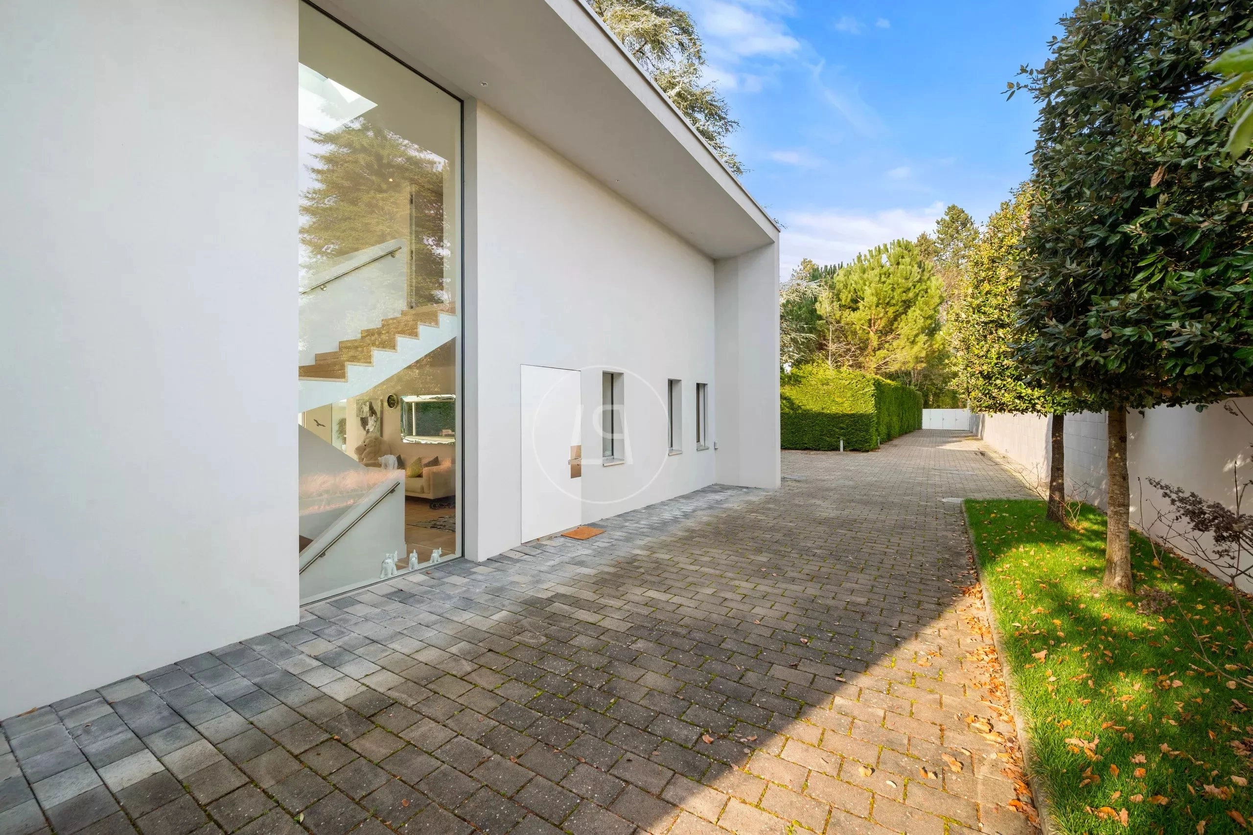 Moderner Außenbereich mit Zufahrt und großer Glasfront