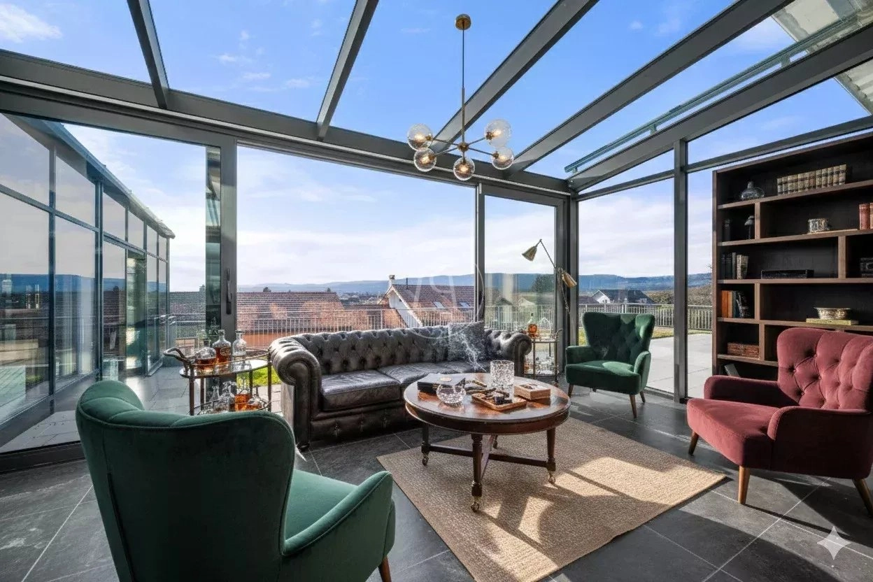 Wohnzimmer mit Wintergarten und Panoramablick