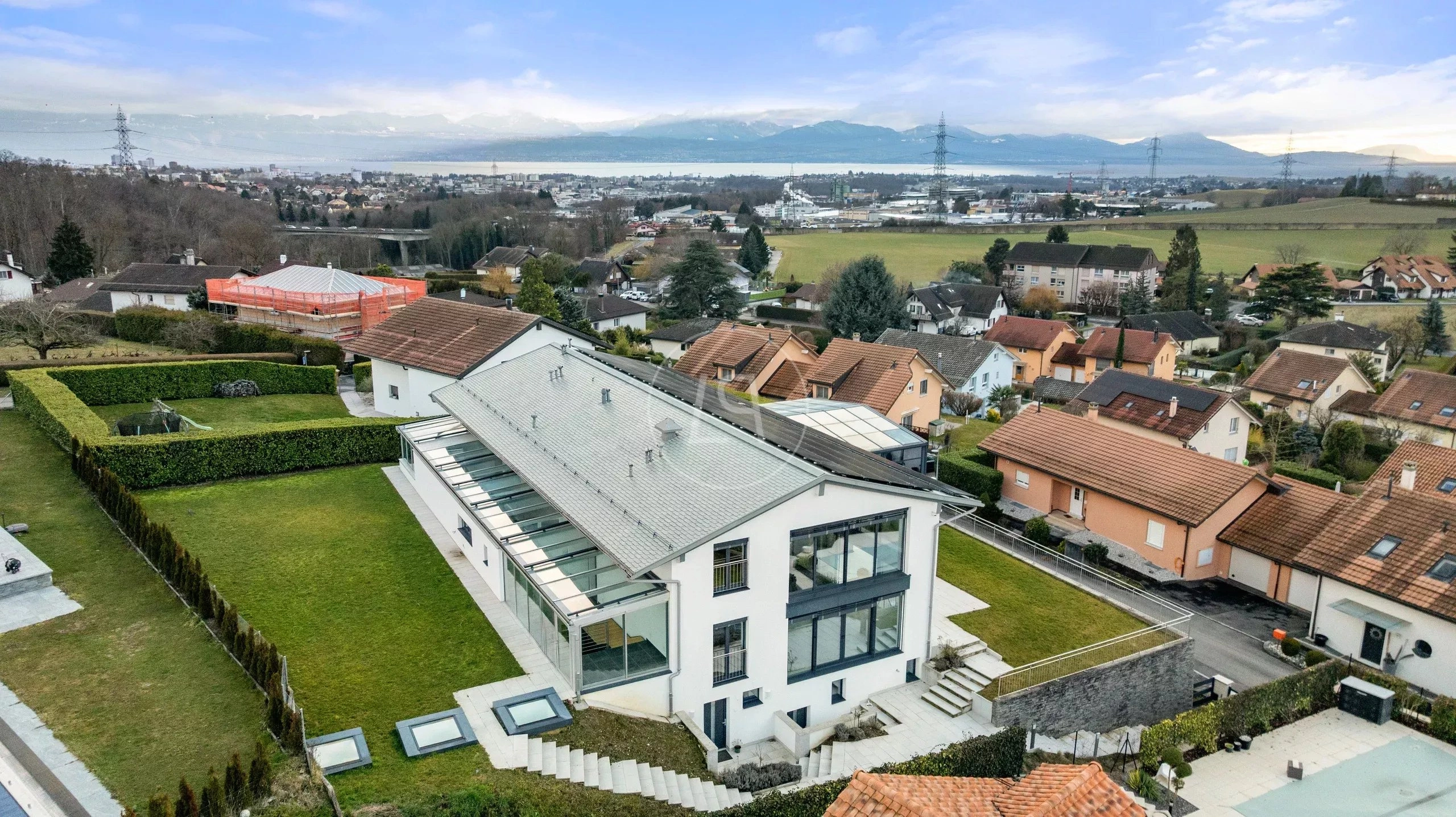 Luftaufnahme eines modernen Einfamilienhauses mit Seeblick