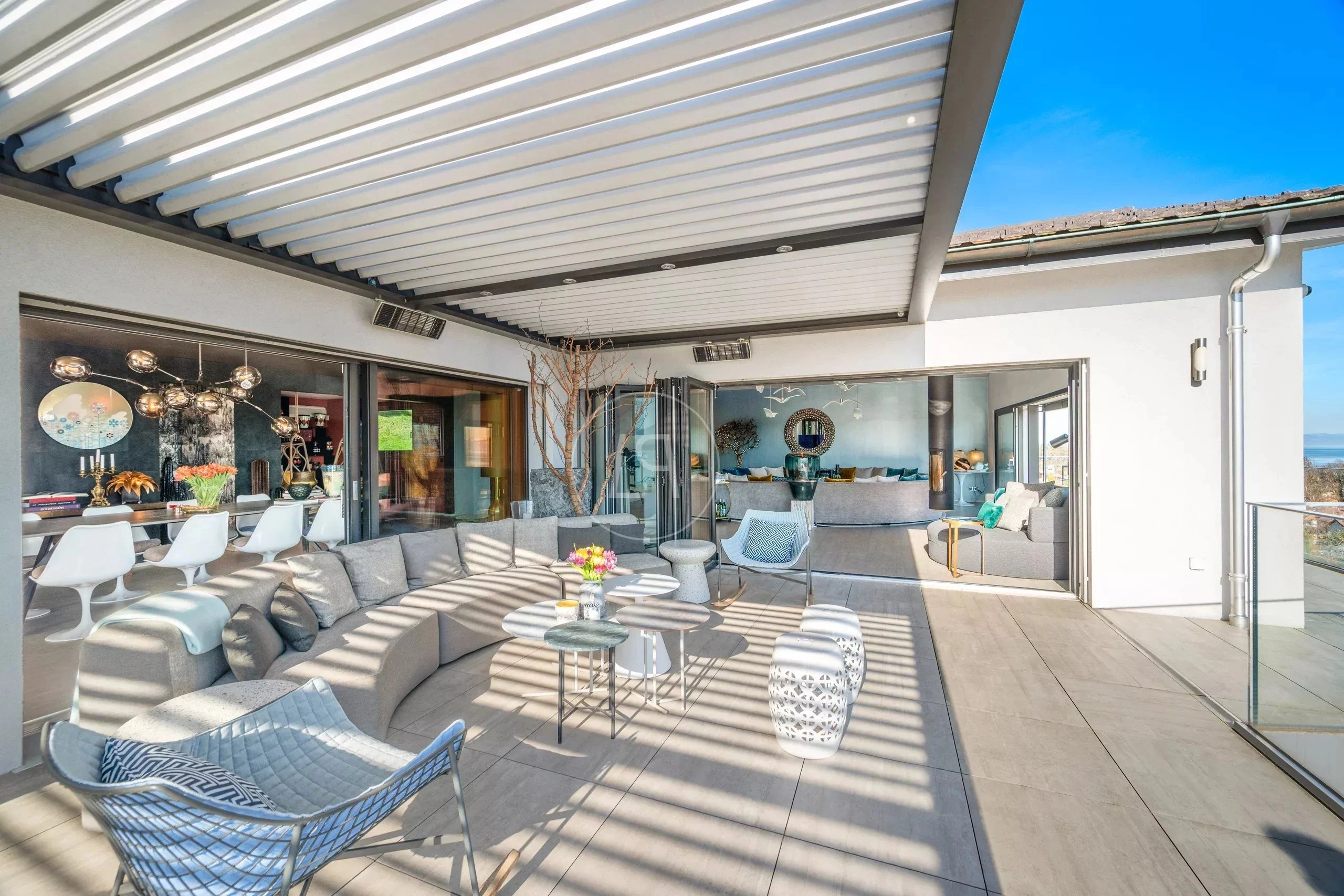 Überdachte Dachterrasse mit Lounge und Blick aufs Wasser
