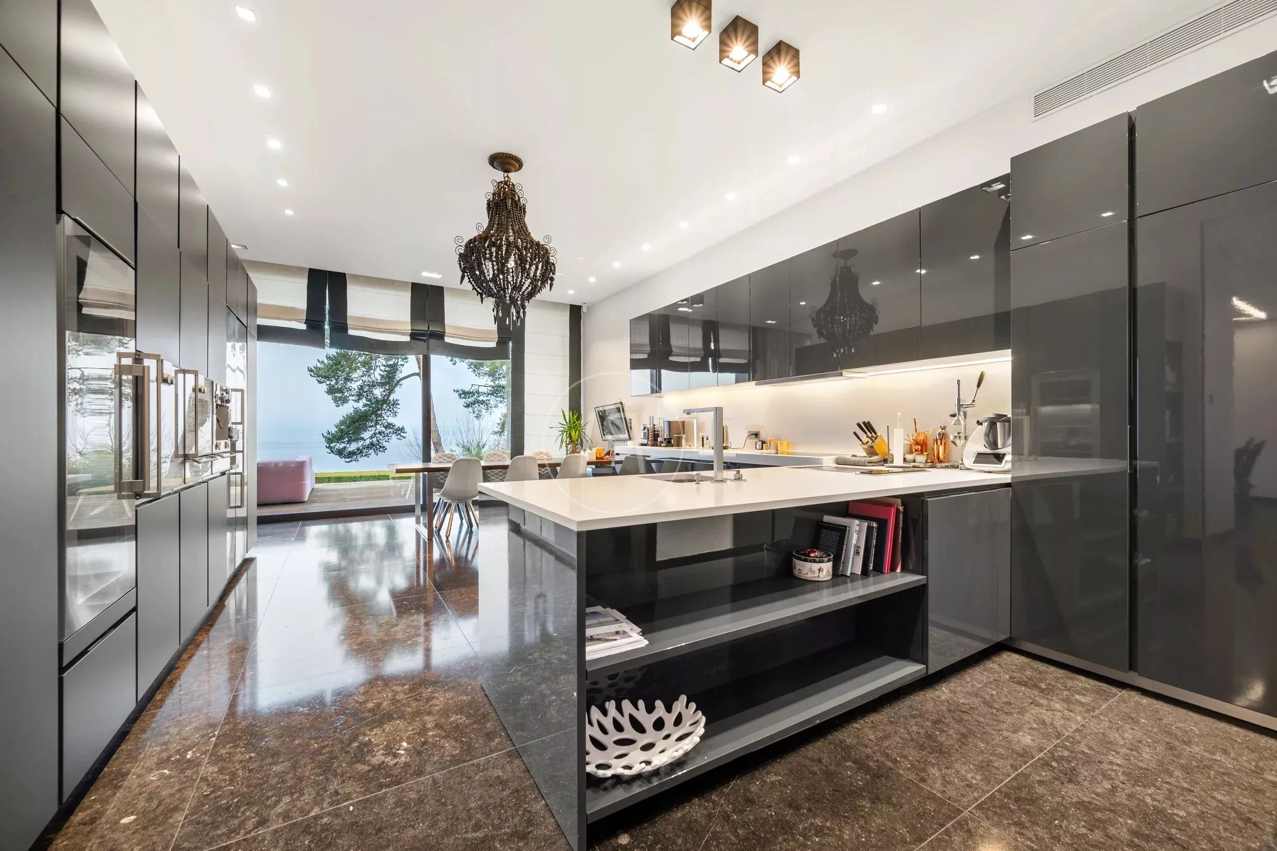 Moderne Designer-Küche mit Insel und Seeblick