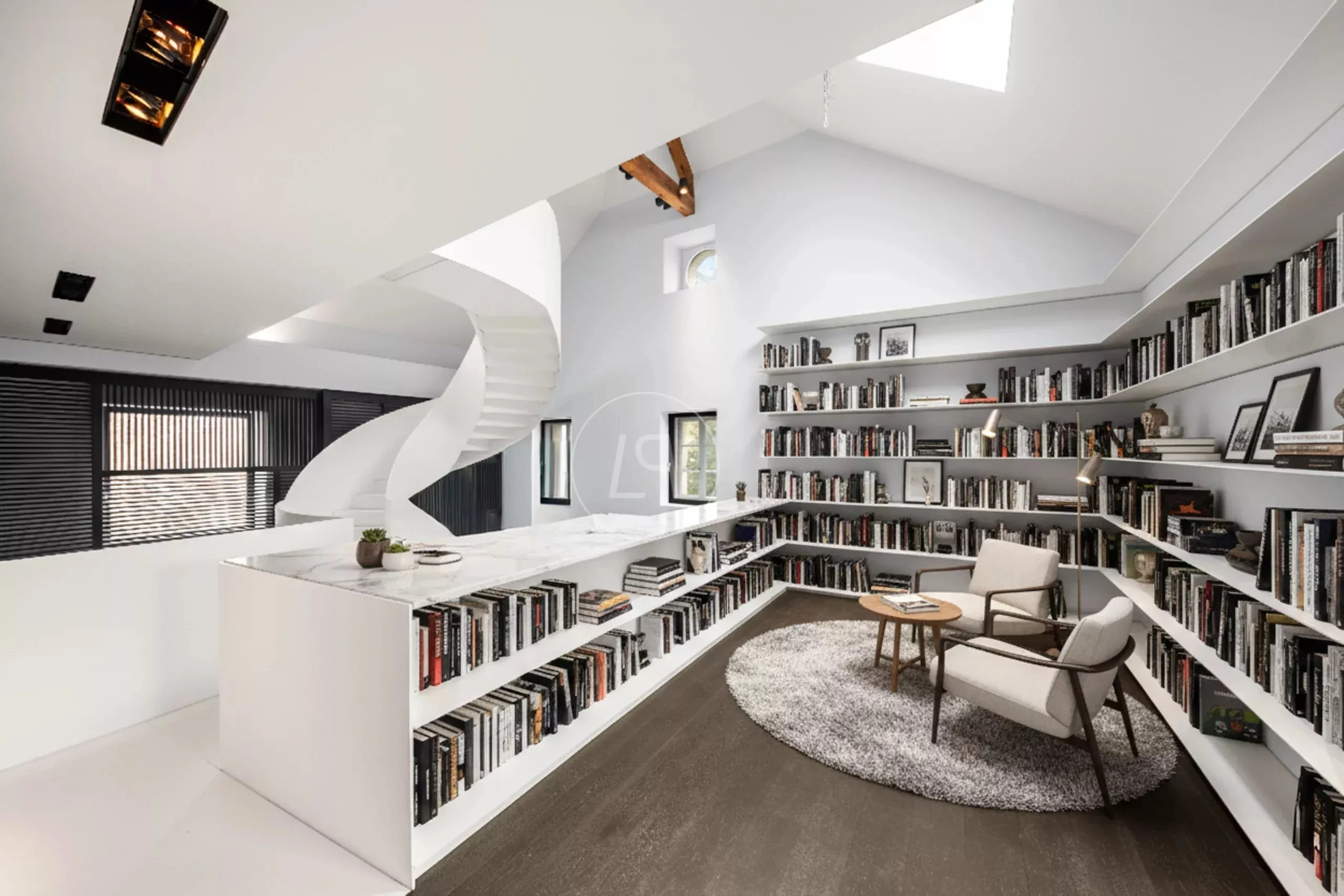 Heller Bibliotheksraum mit Galerie und Wendeltreppe