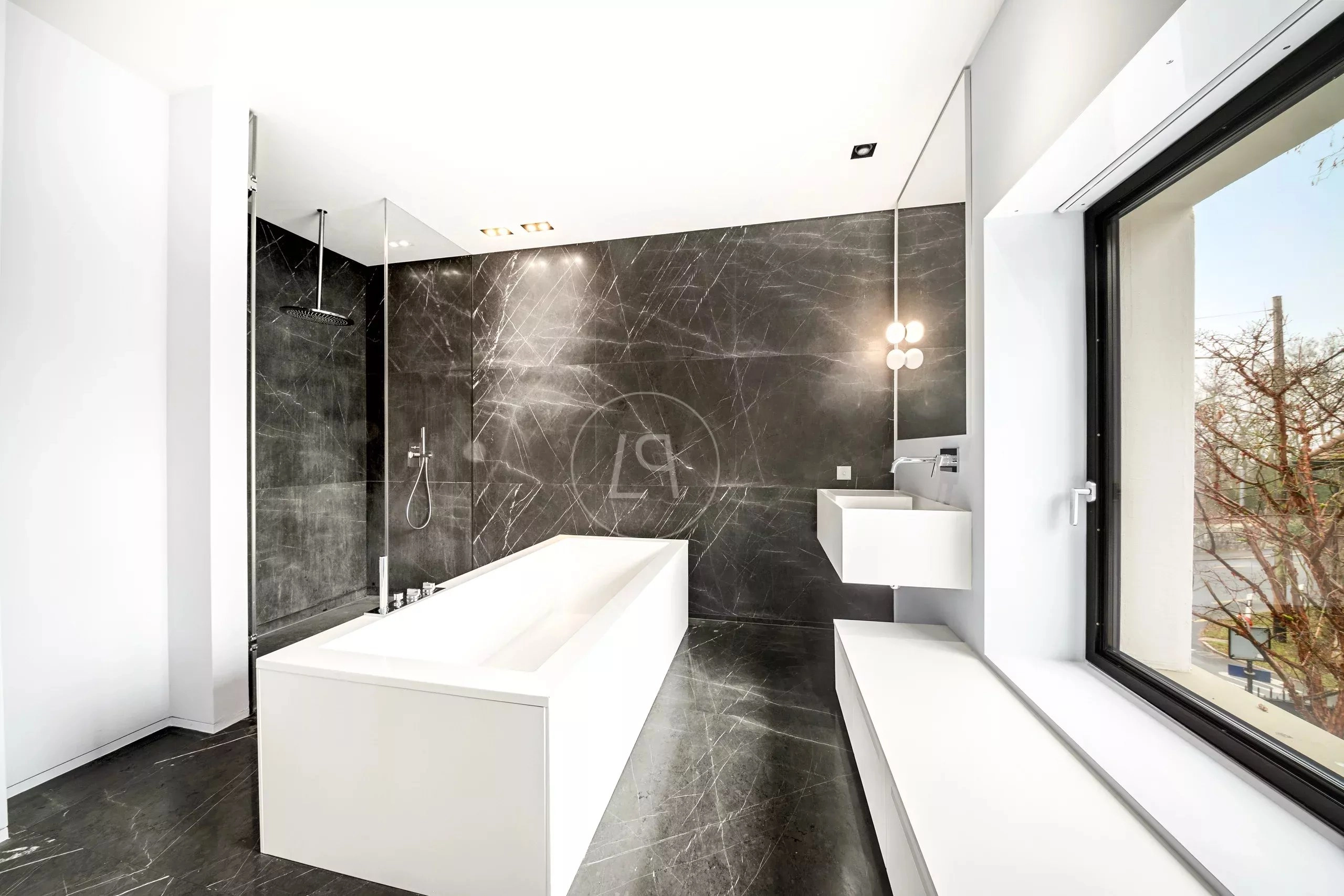 Modernes Bad mit dunkler Steinoptik und Badewanne