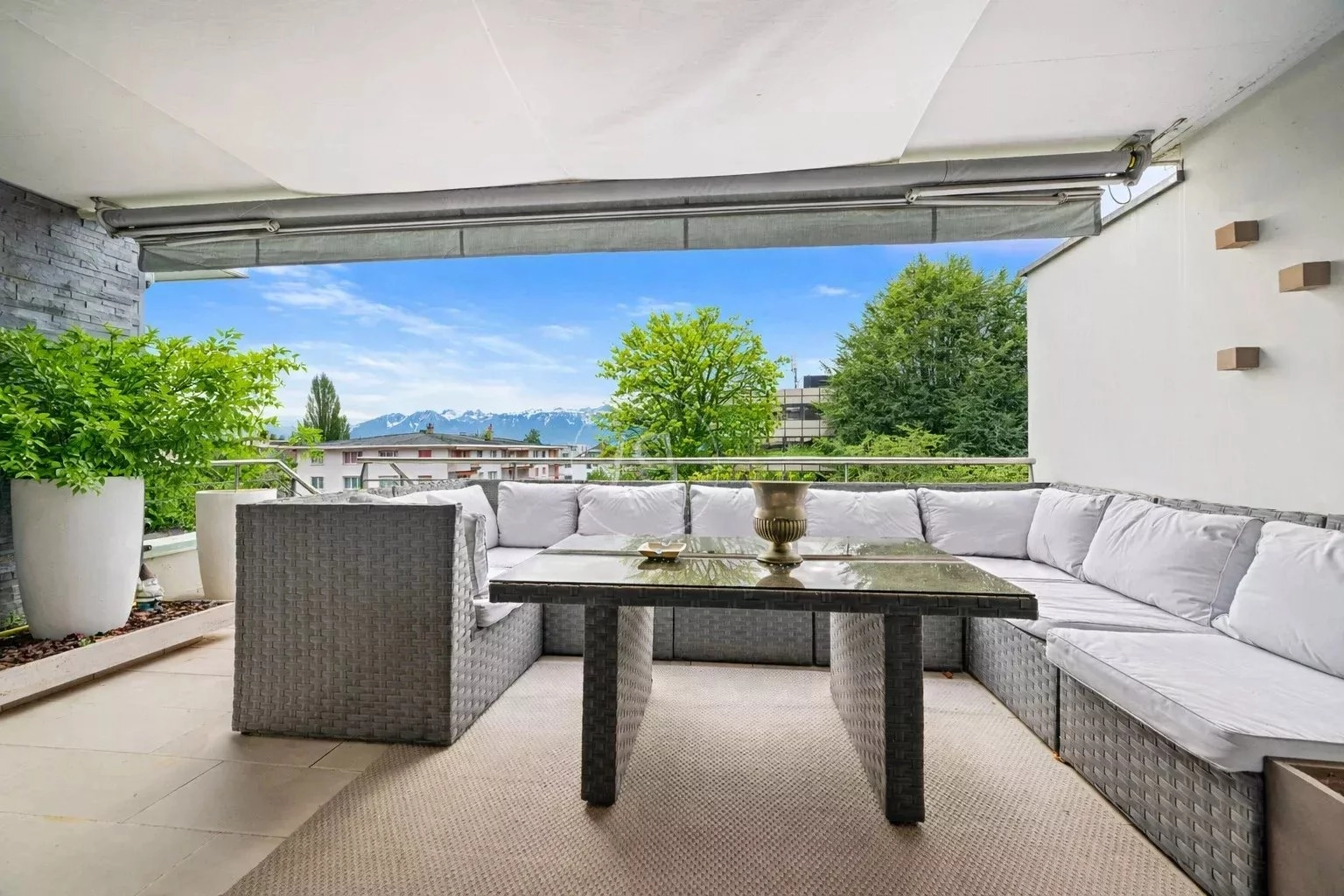 Großzügige Terrasse mit Lounge-Möbeln und Bergblick