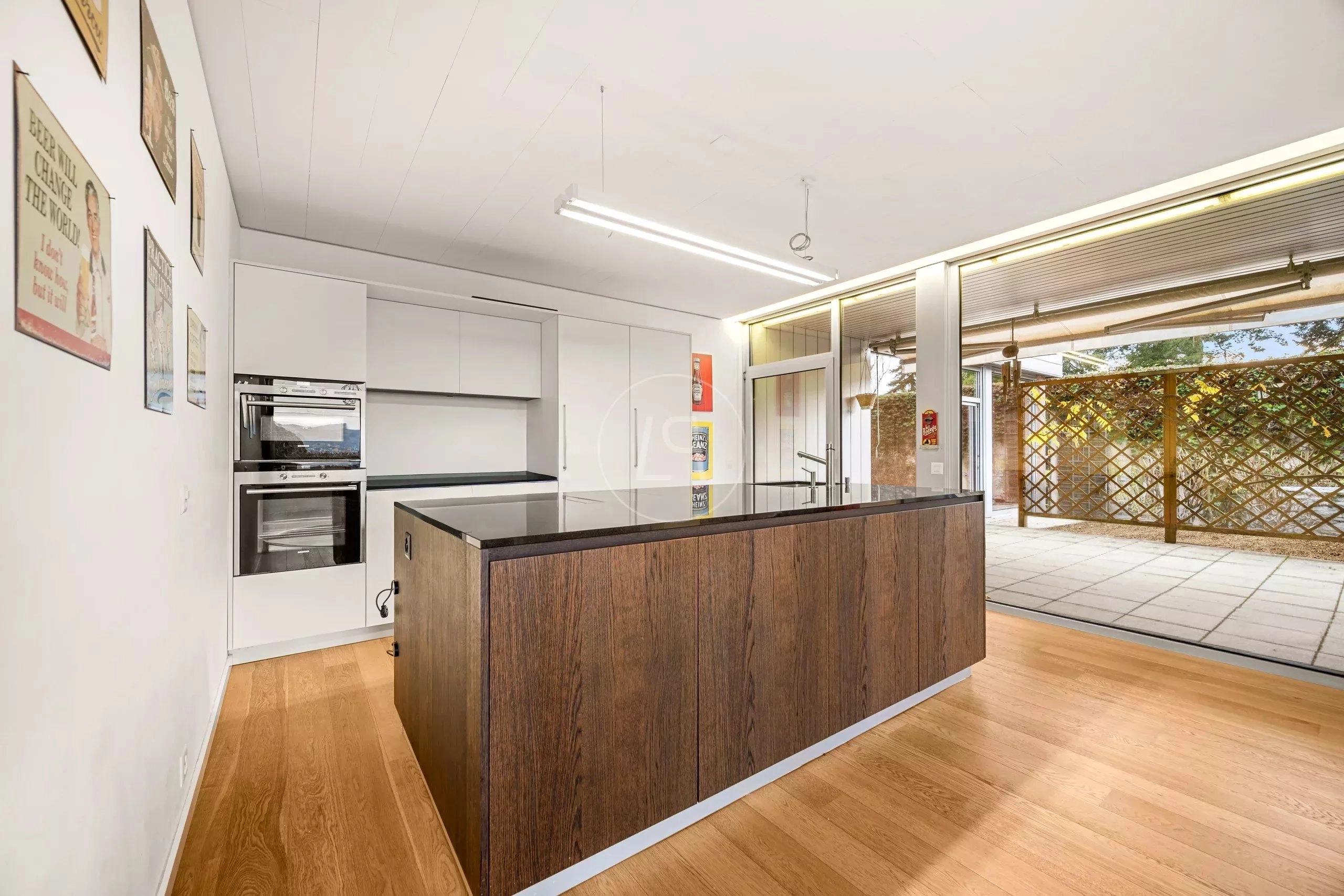 Moderne Küche mit Kochinsel und Terrassenzugang