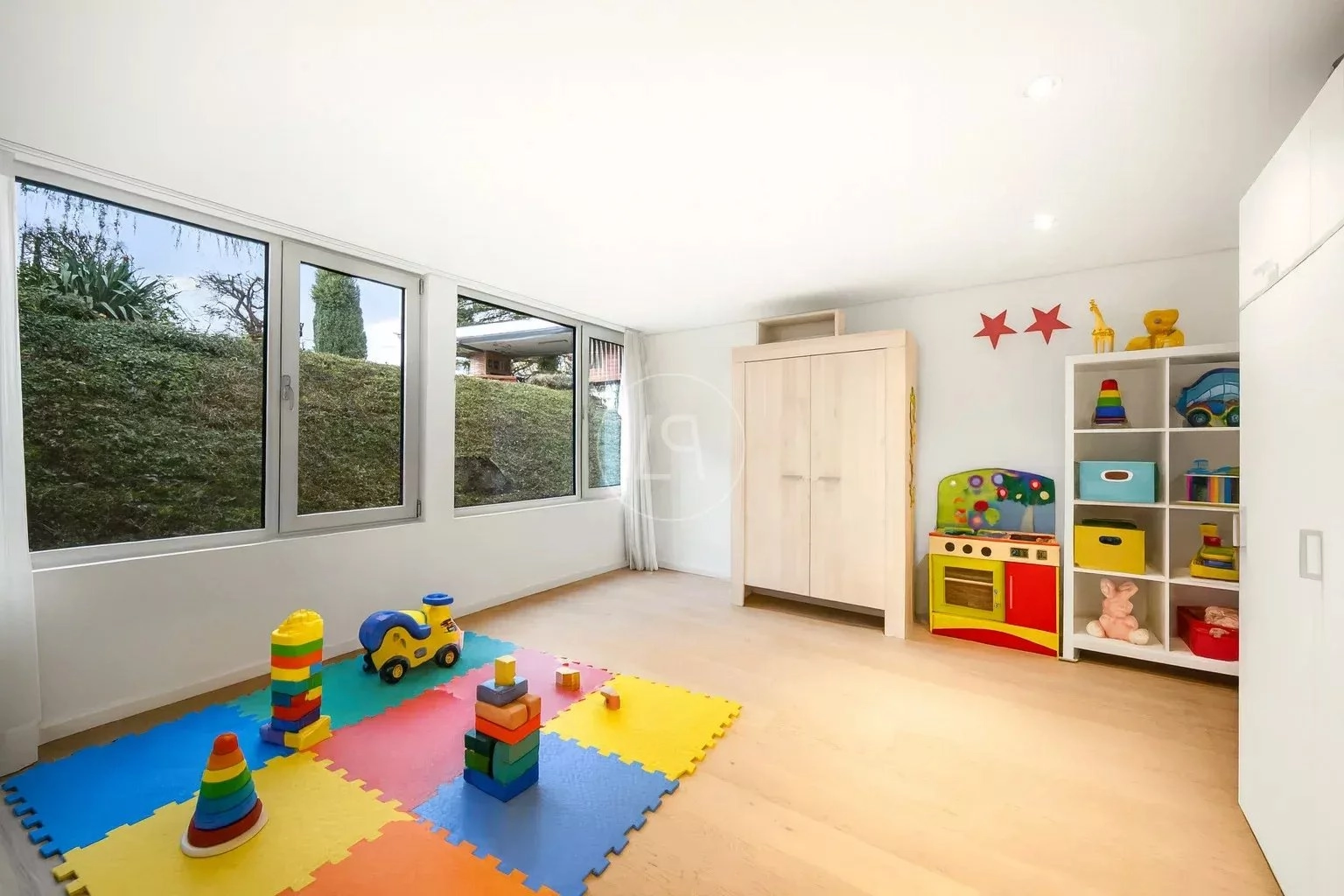 Heller Spiel- bzw. Kinderraum mit großen Fenstern