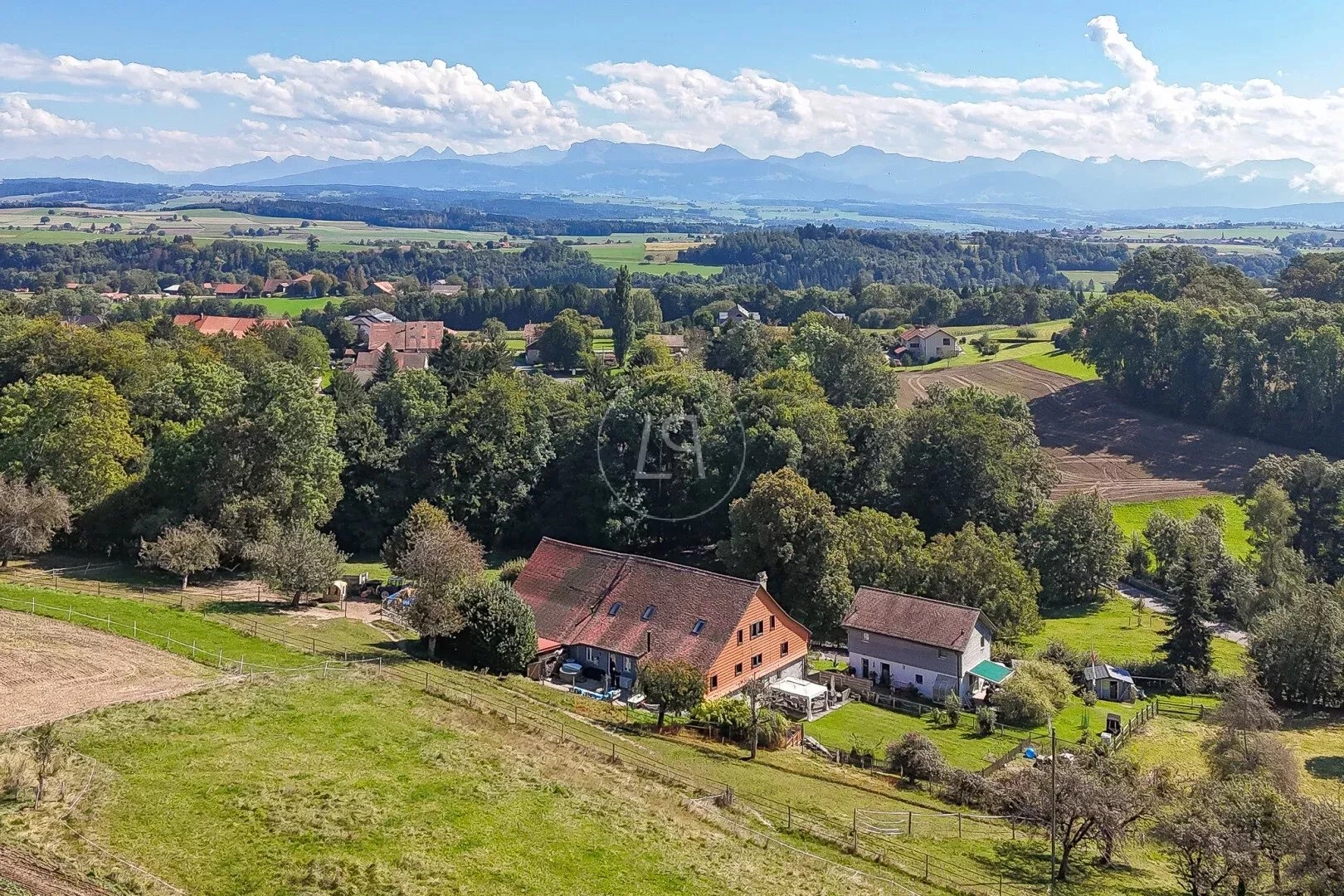 Landschaft mit Bauernhaus und Alpenblick