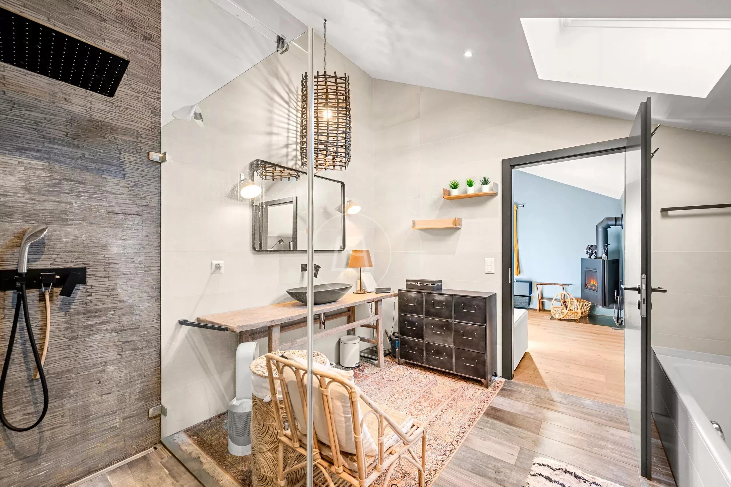 Modernes Badezimmer mit offenem Duschbereich und Blick ins angrenzende Zimmer