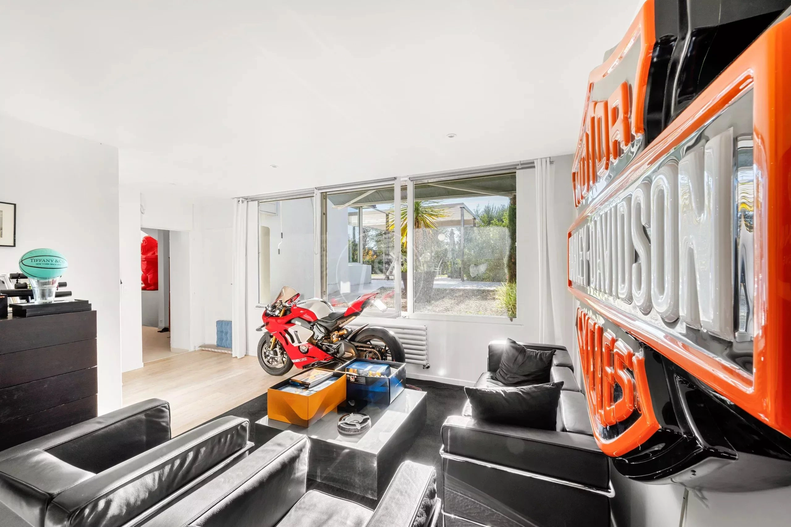 Modernes, helles Wohnzimmer mit auffälligem Motorrad-Display