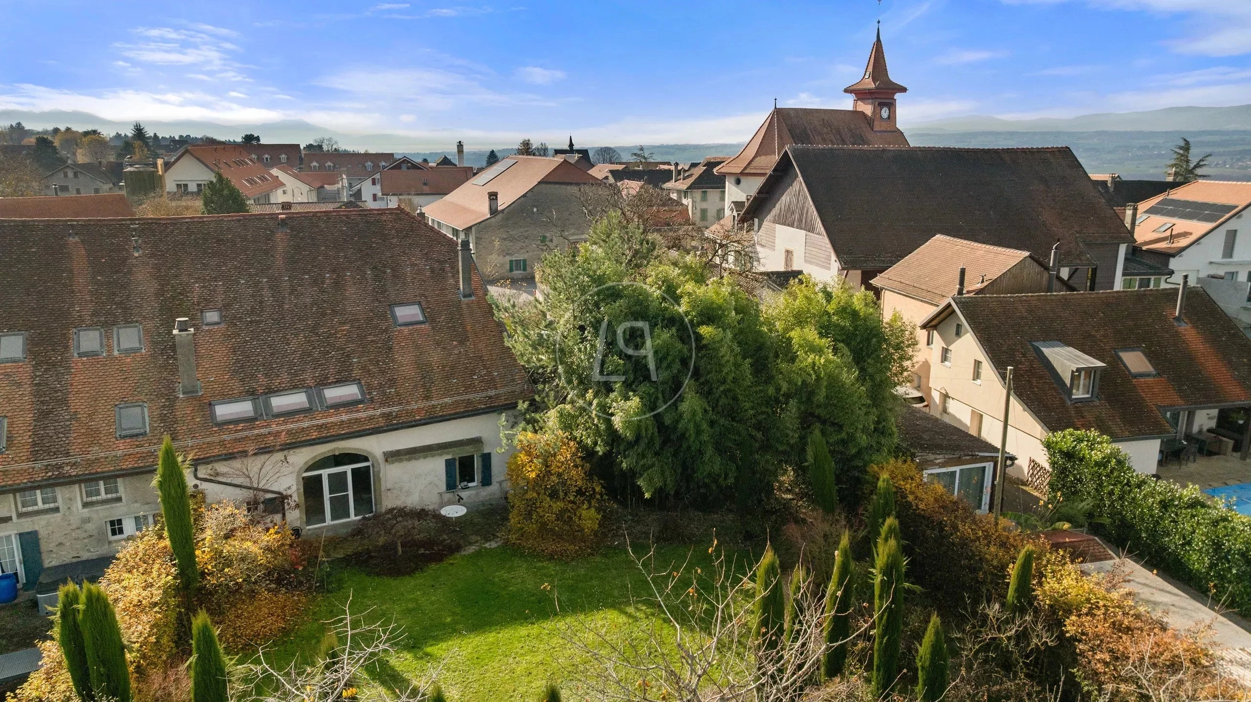 Dorf-/Stadtansicht mit Gärten und Kirchturm