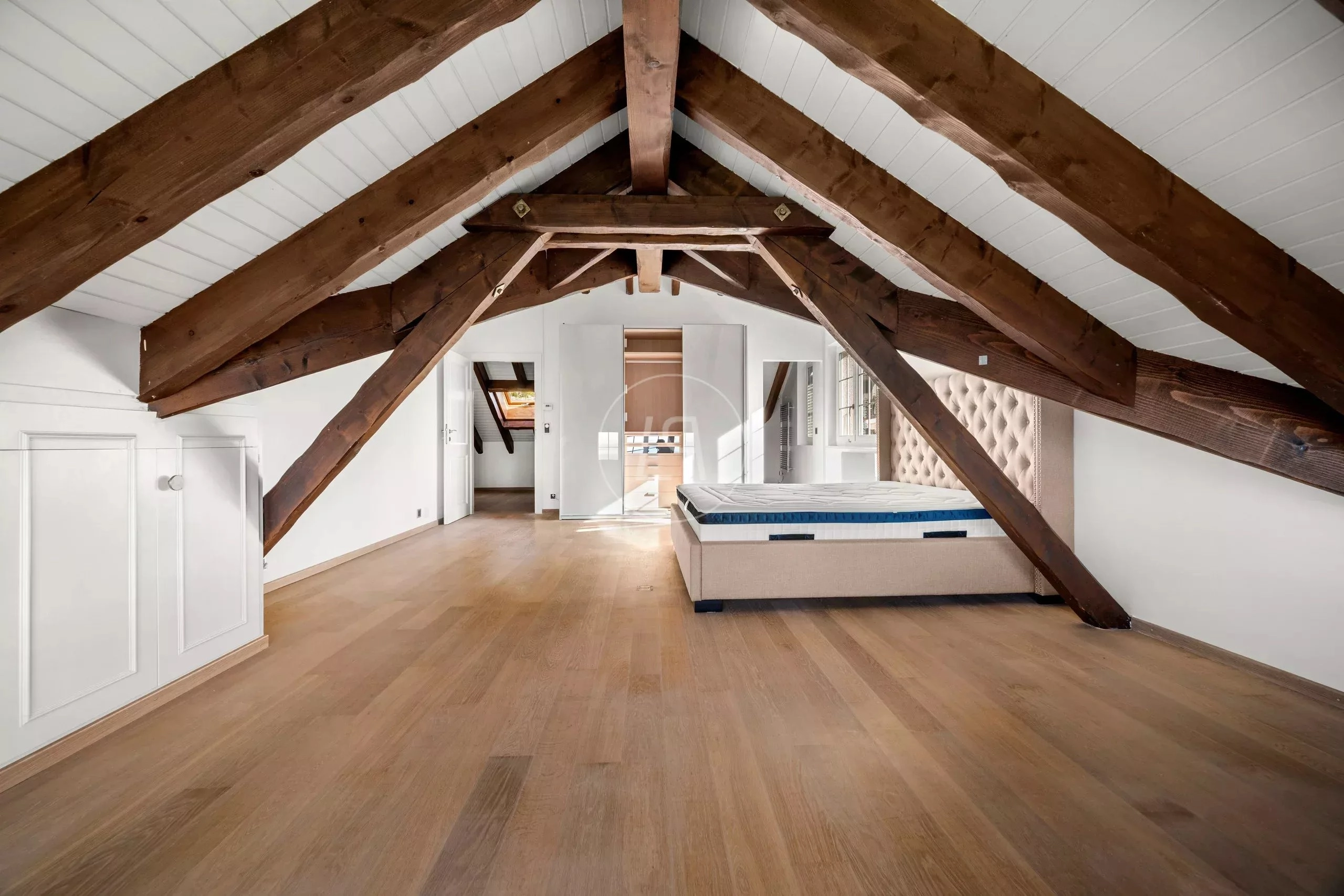 Dachgeschoss-Schlafzimmer mit sichtbaren Balken