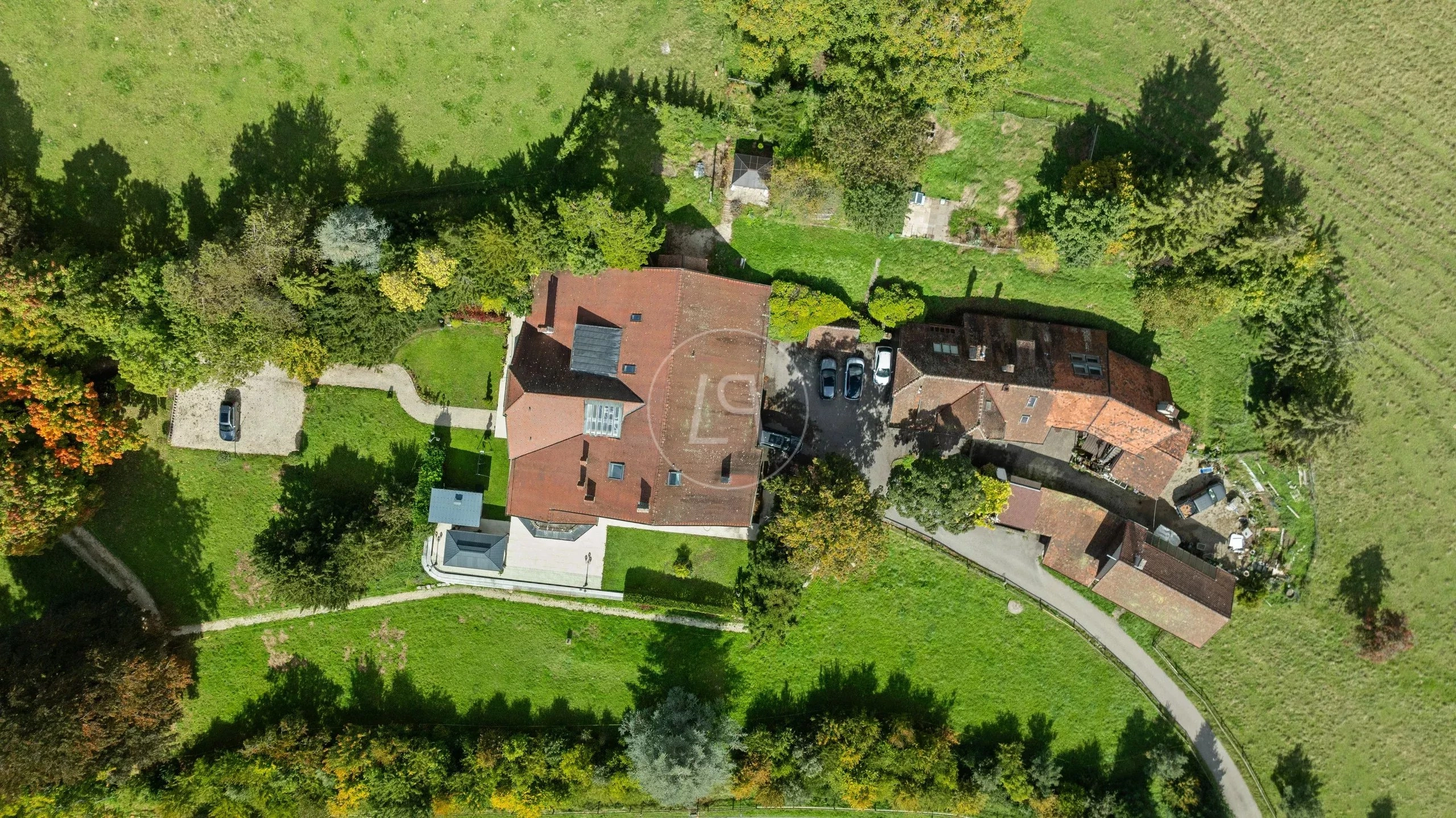 Luftaufnahme eines ländlichen Anwesens mit Wohnhäusern und Gartenflächen