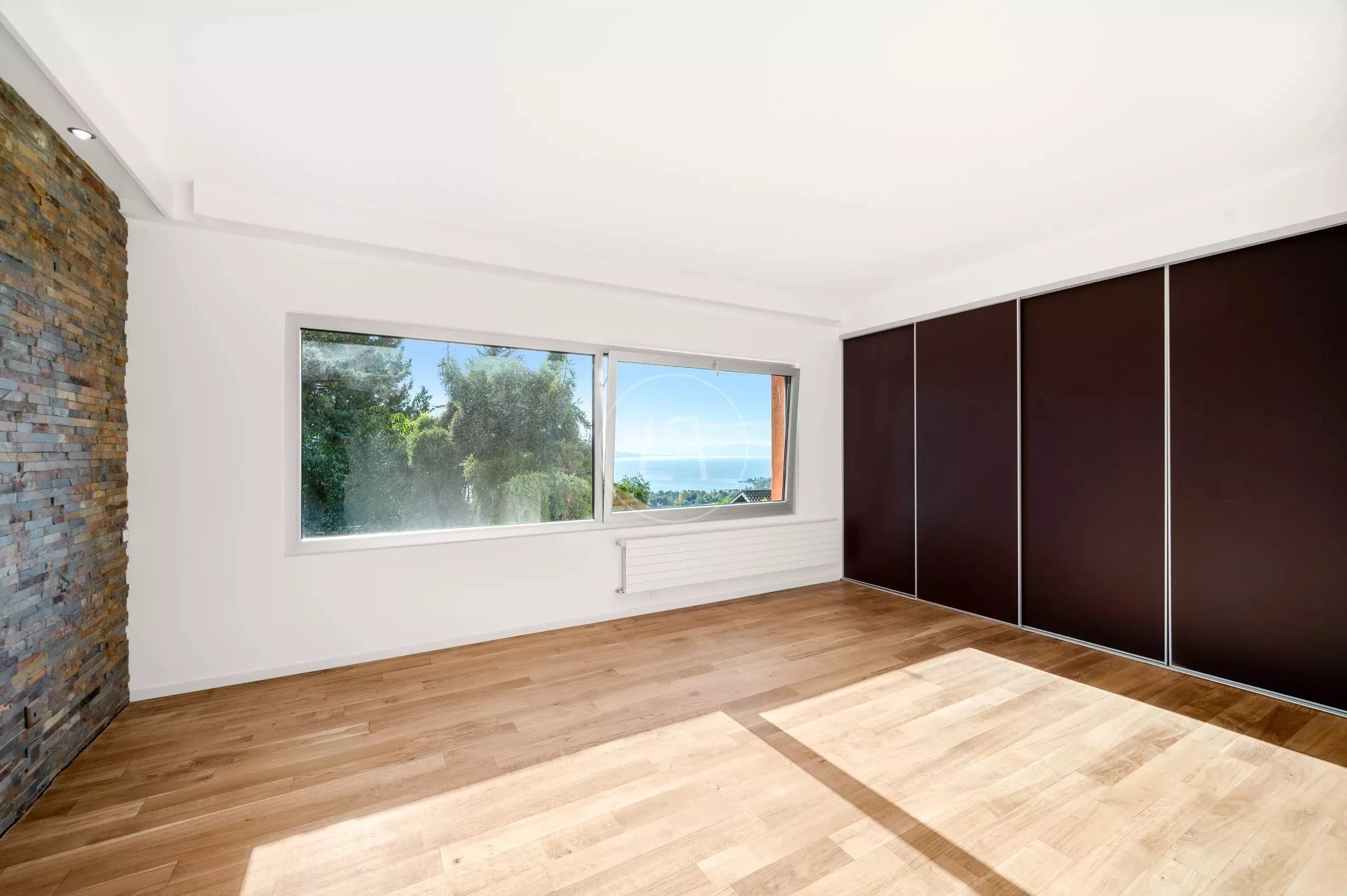 Heller leerer Raum mit Panoramafenster und Holzboden