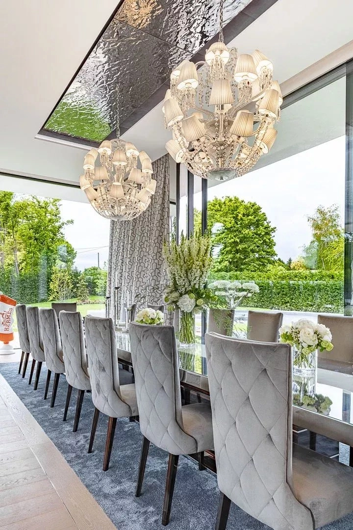 Eleganter Wintergarten mit langen Esstisch und Kronleuchtern