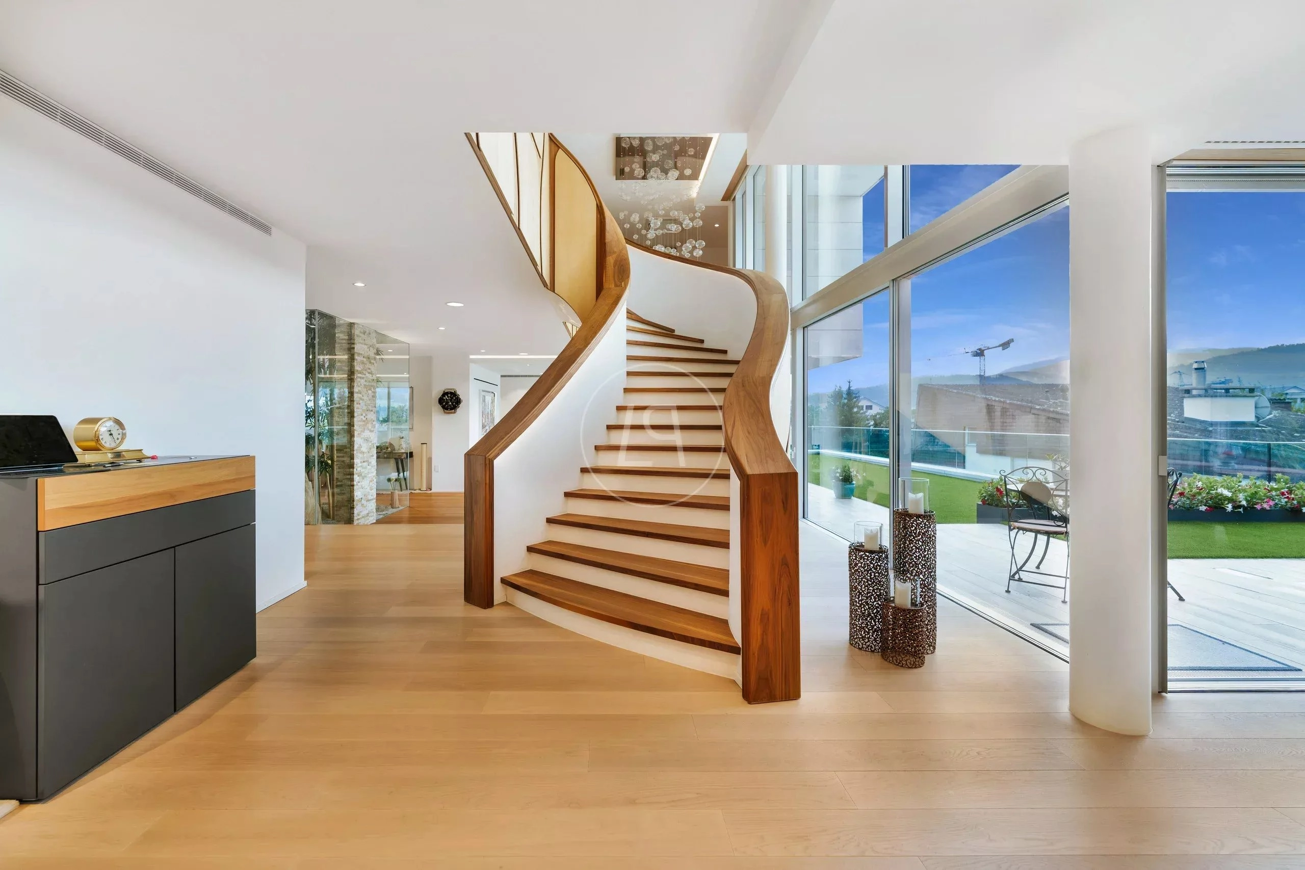 Elegante Diele mit geschwungener Treppe und Panoramafenstern