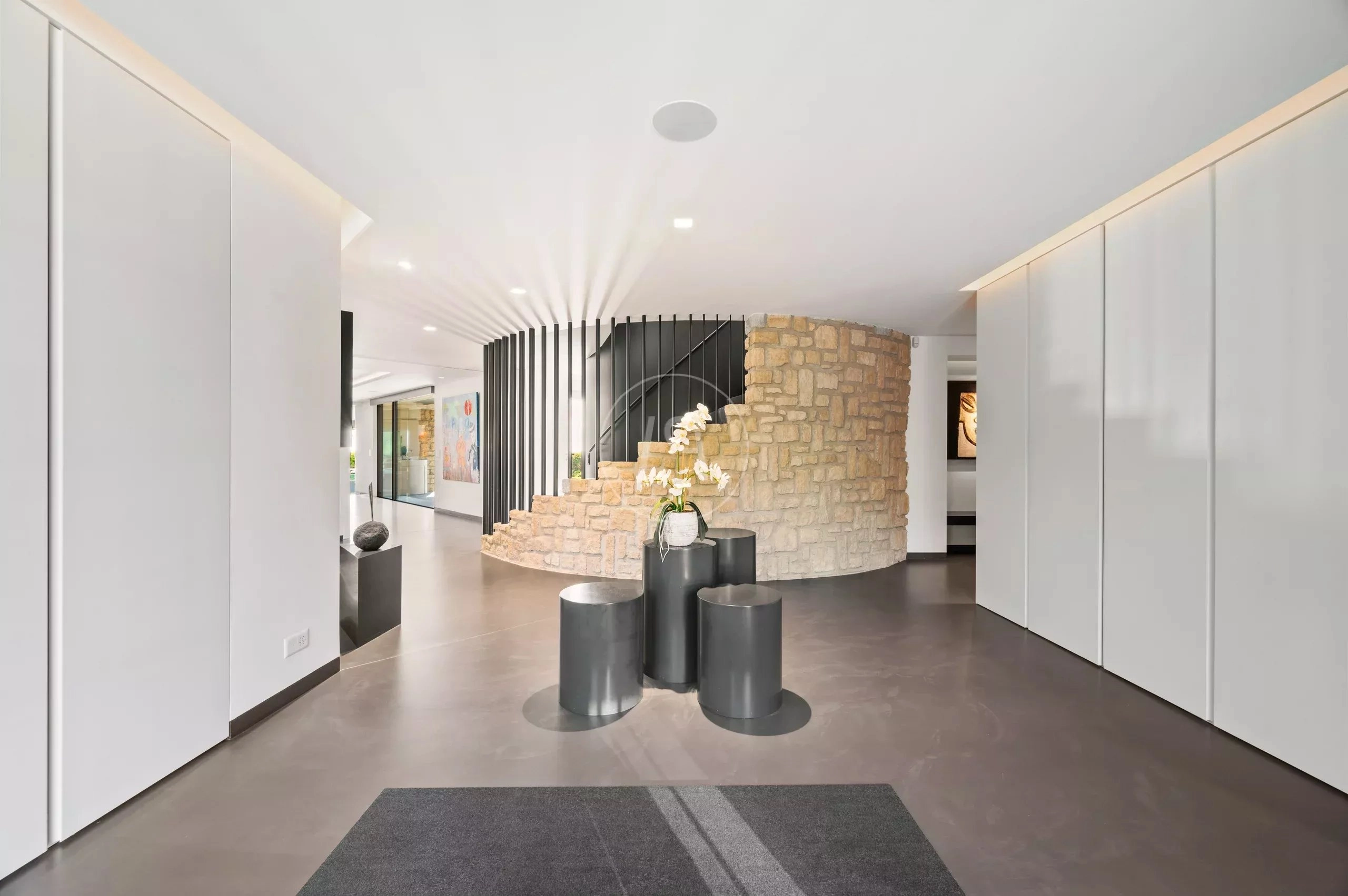 Moderner Eingangsbereich mit Treppe und Steinwand