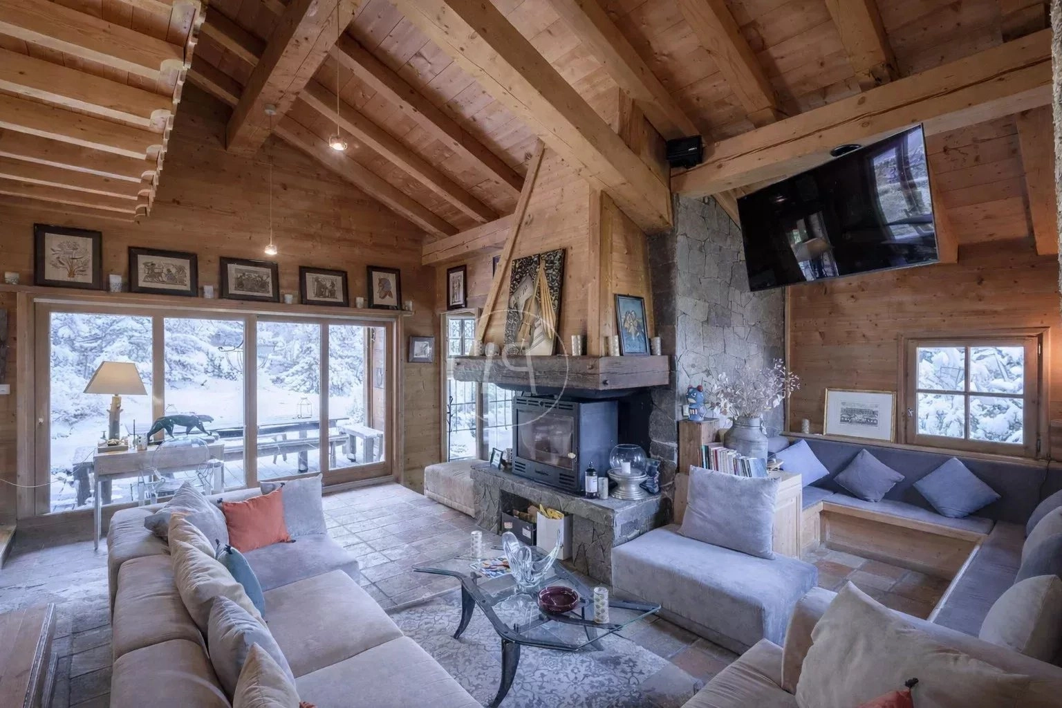 Gemütliches alpines Wohnzimmer mit Kamin und großer Verglasung