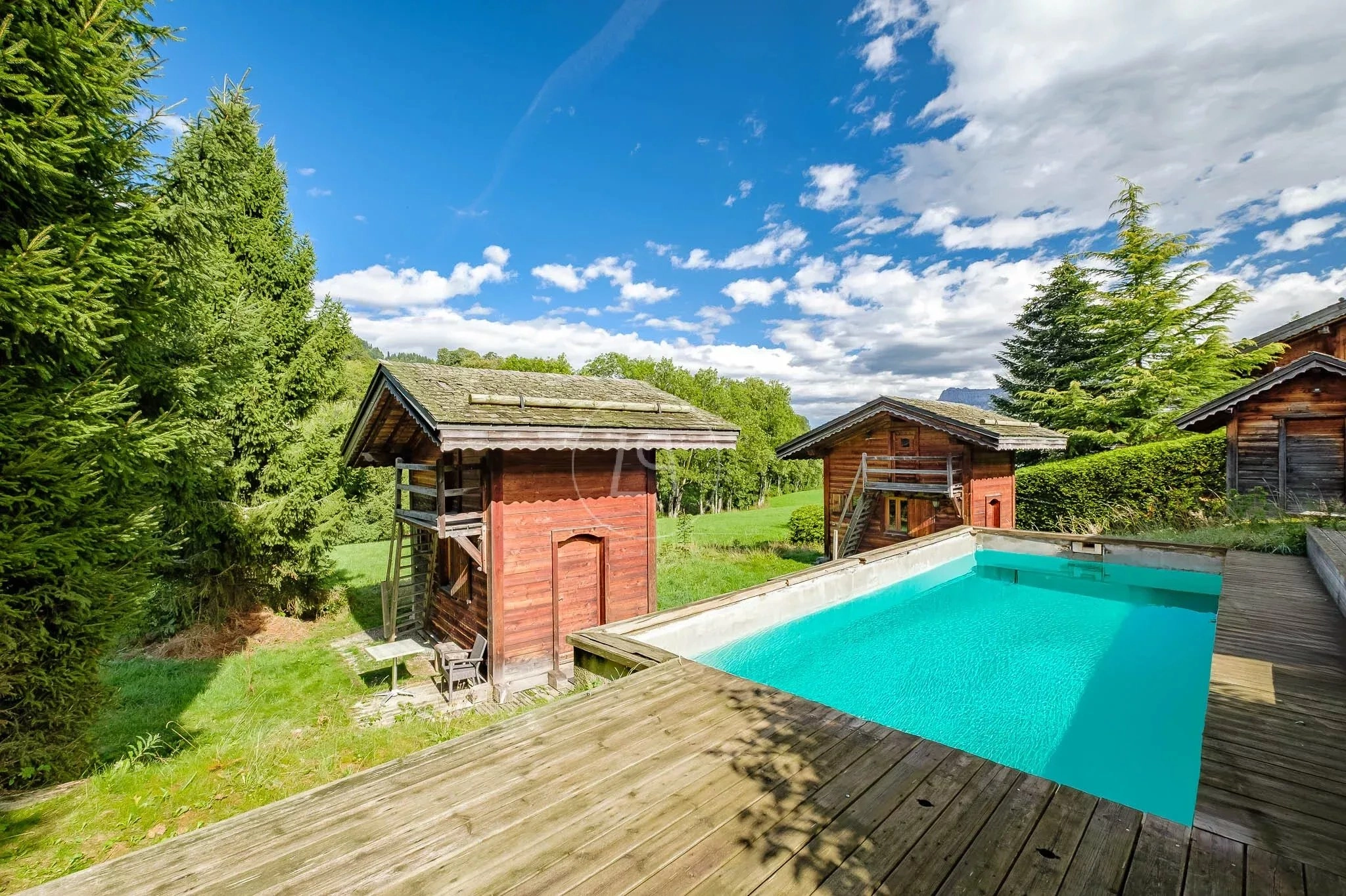 Außenansicht mit Pool und Holzchalets