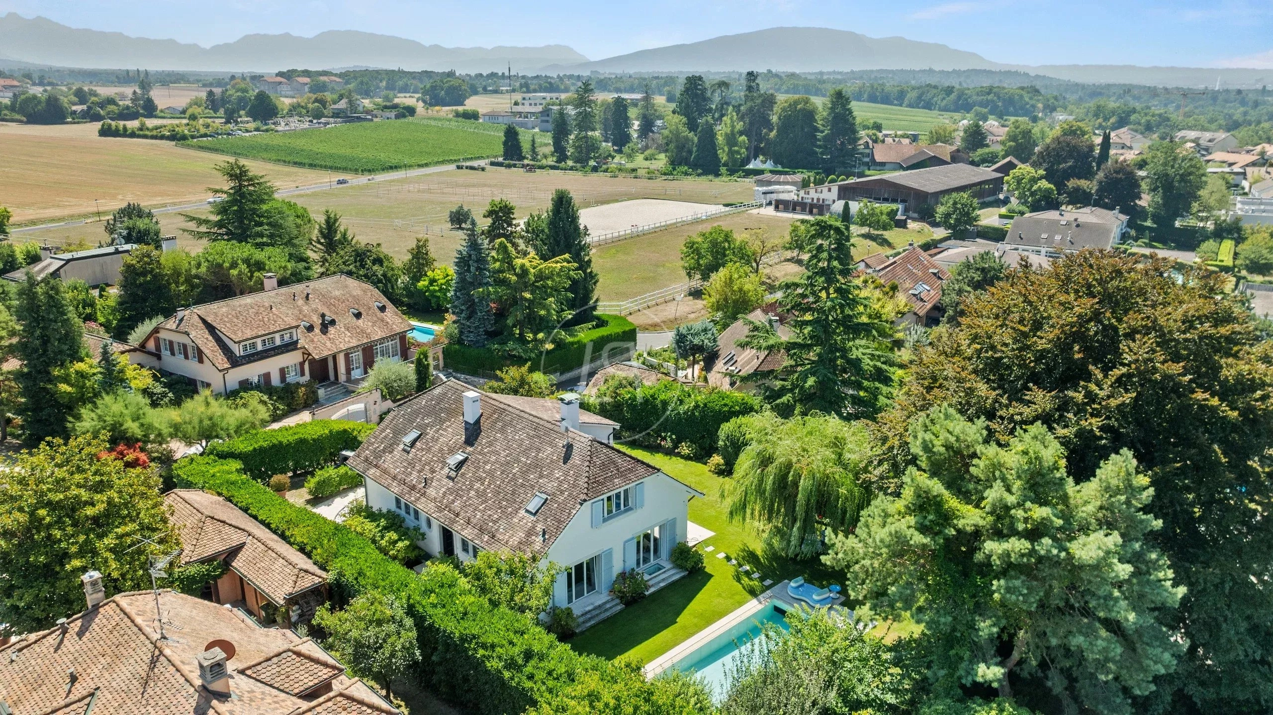 Ländliche Luftaufnahme eines Wohngebiets mit Pool und Bergblick
