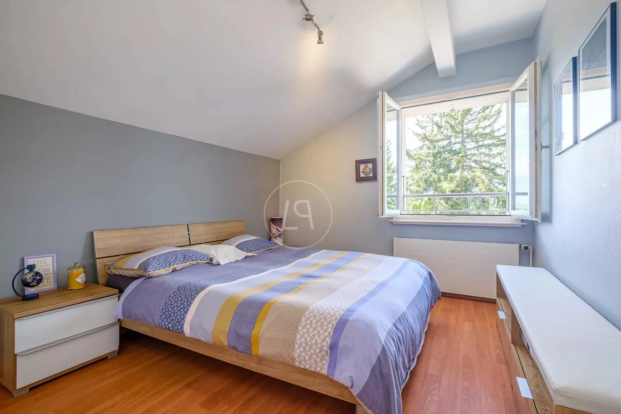 Helles Schlafzimmer mit Dachschräge und offenem Fenster