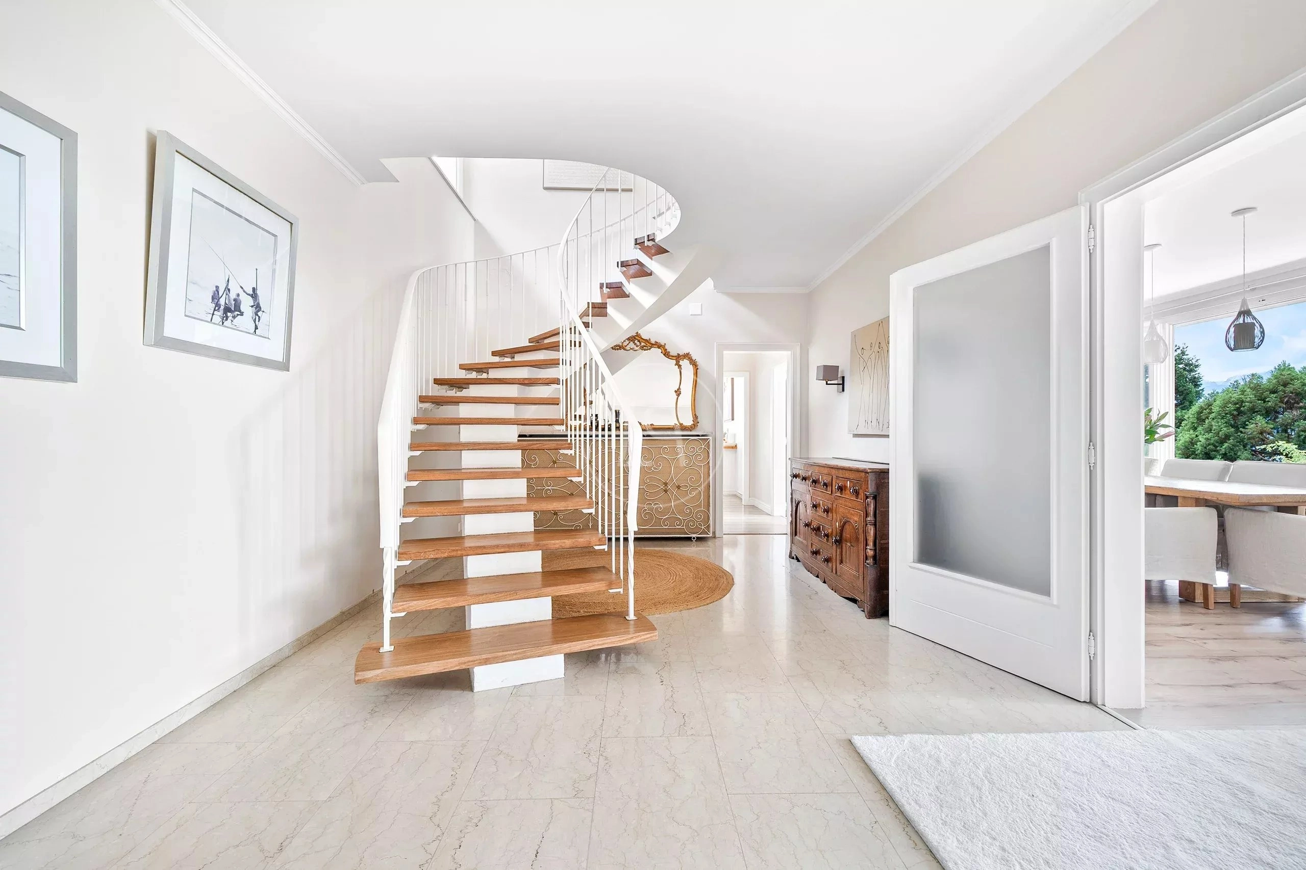 Heller Flur mit geschwungener Treppe