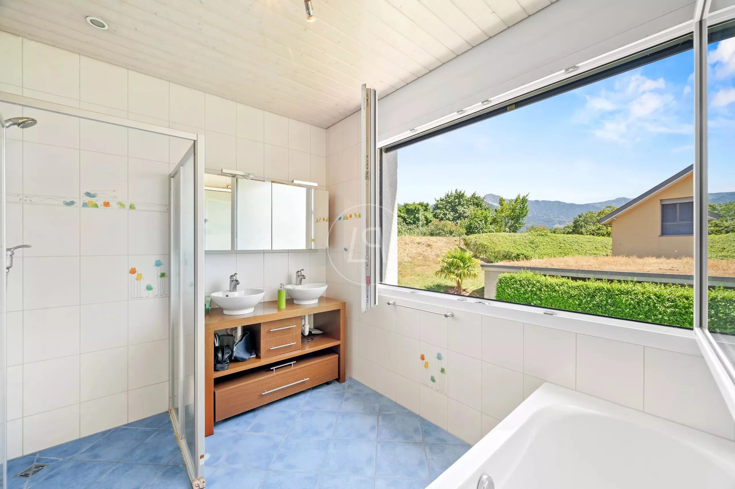 Helles Badezimmer mit großer Fensterfront und Blick ins Grüne