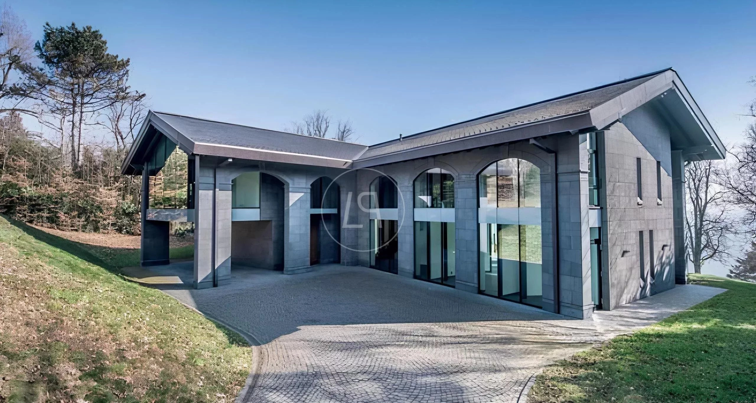 Moderne Villa mit geschwungenem Dach und großer Glasfassade