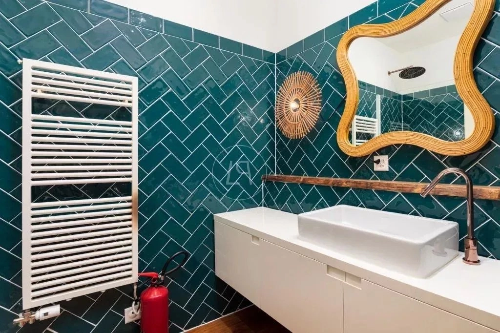 Modernes Badezimmer mit petrolfarbenen Fliesen und Holzspiegel