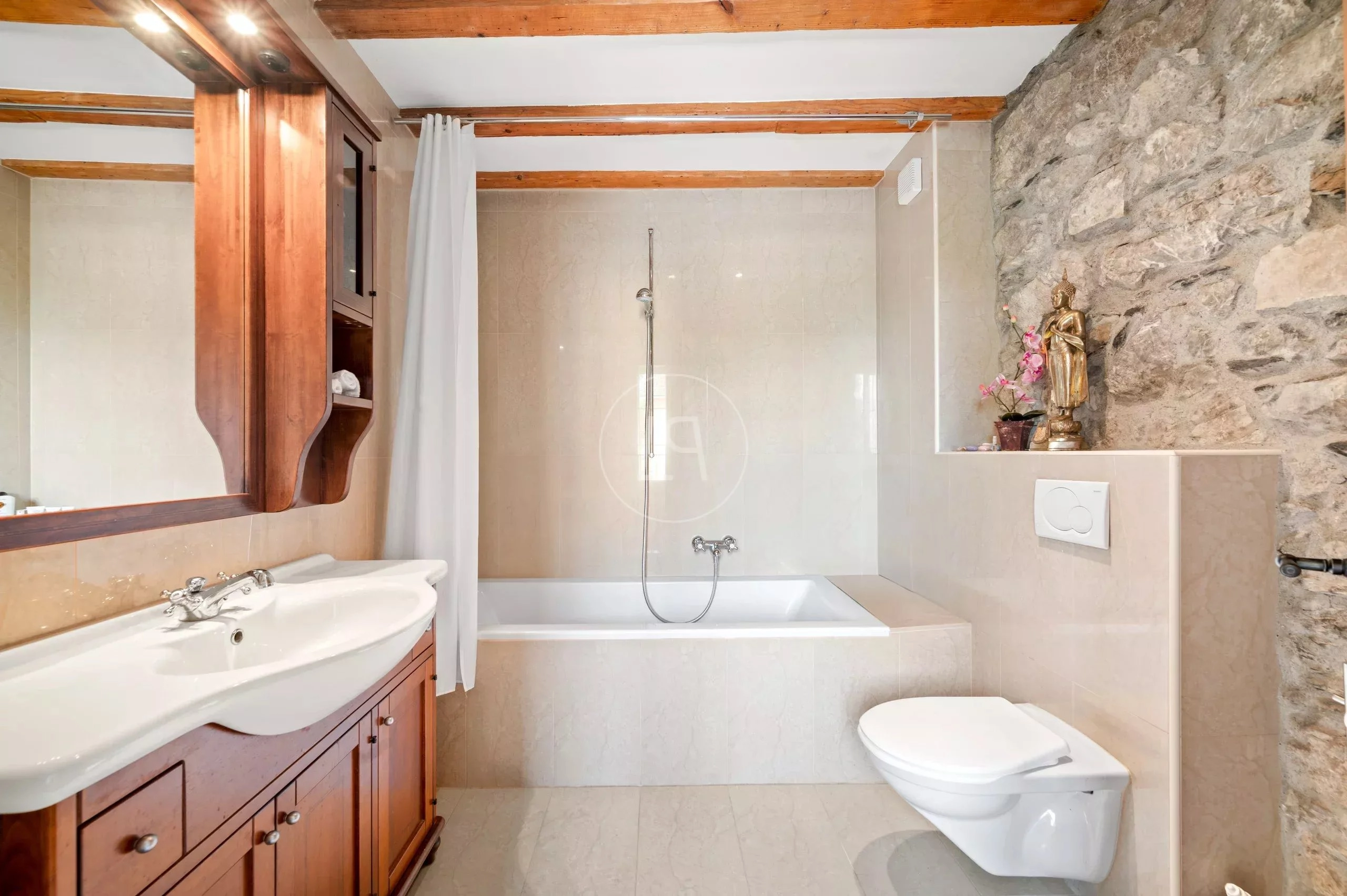 Helles Badezimmer mit Badewanne, Waschtisch und Natursteinwand