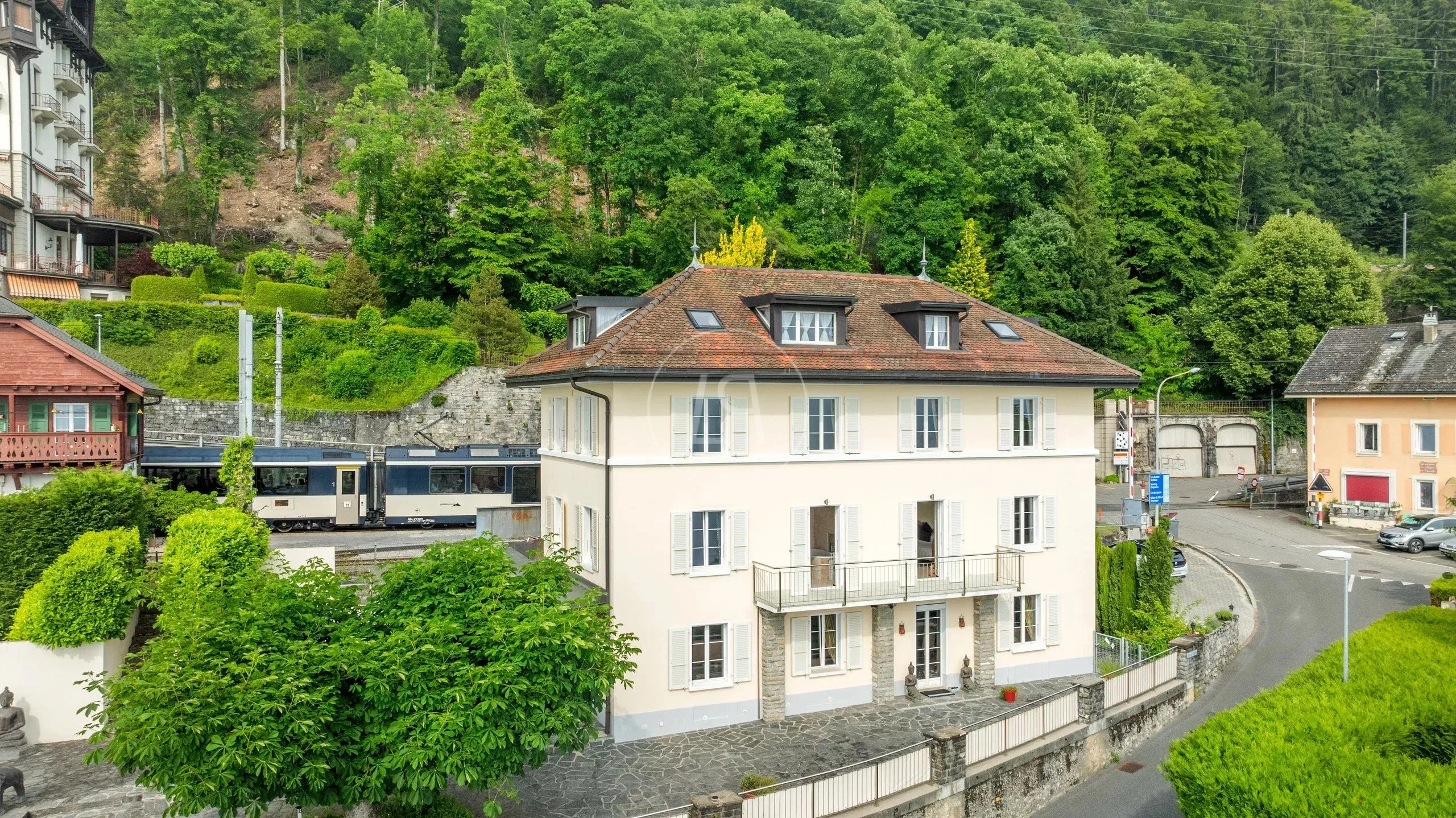 Ansicht eines villenartigen Wohnhauses in grüner Hanglage