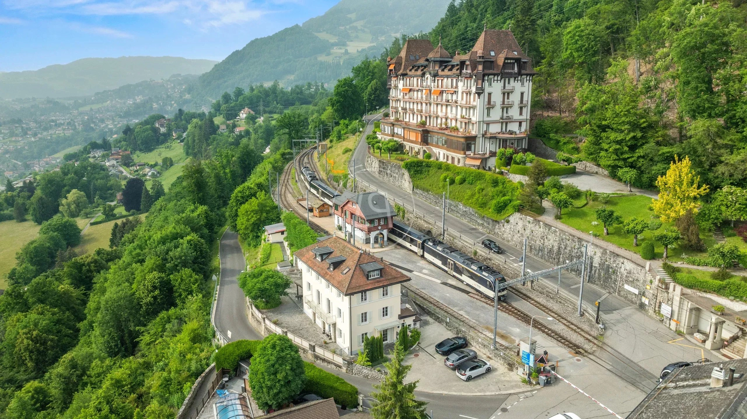 Luftaufnahme eines bergigen Hotel- und Bahnumfelds