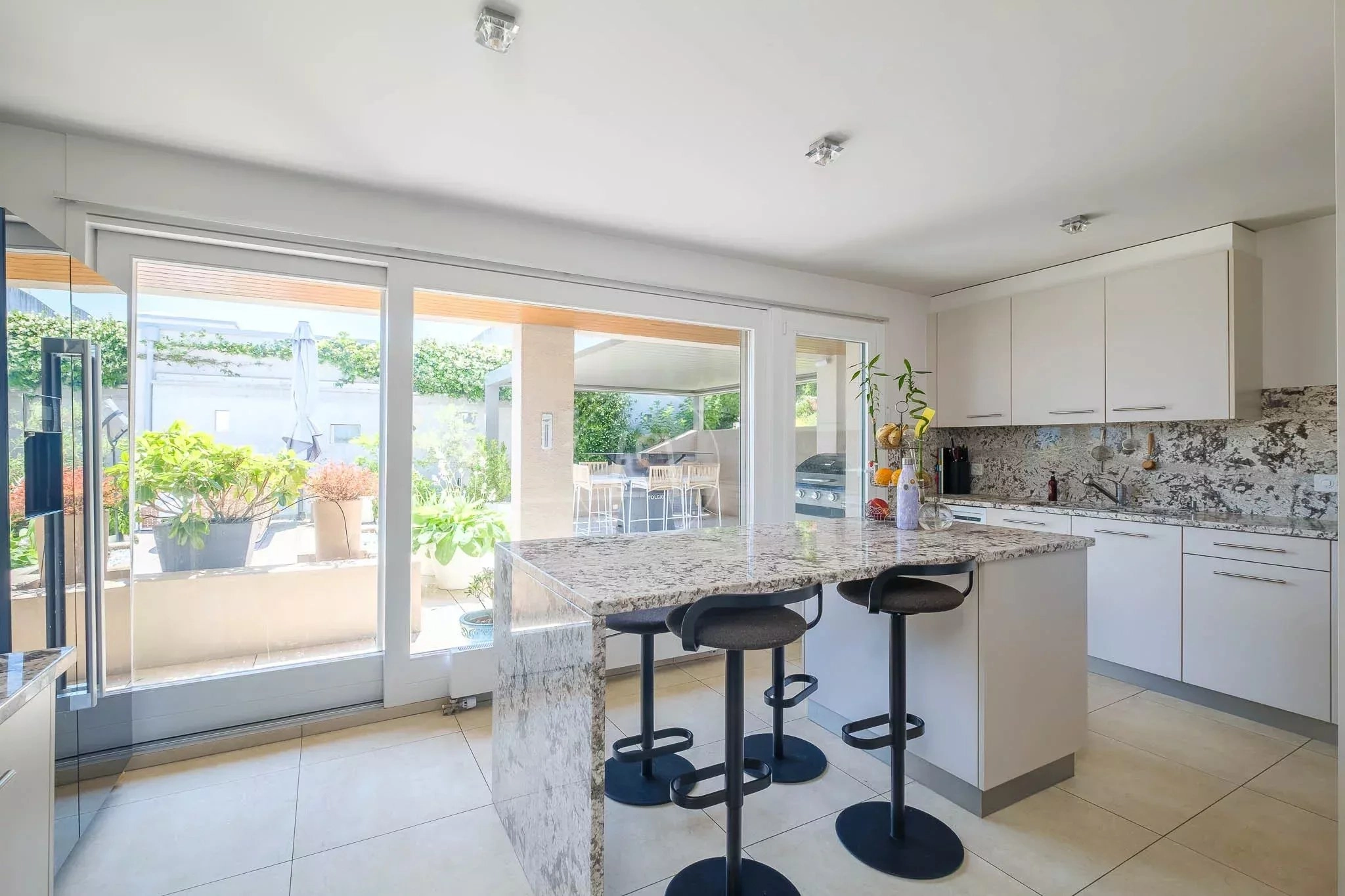 Moderne Küche mit Insel und Terrassenblick
