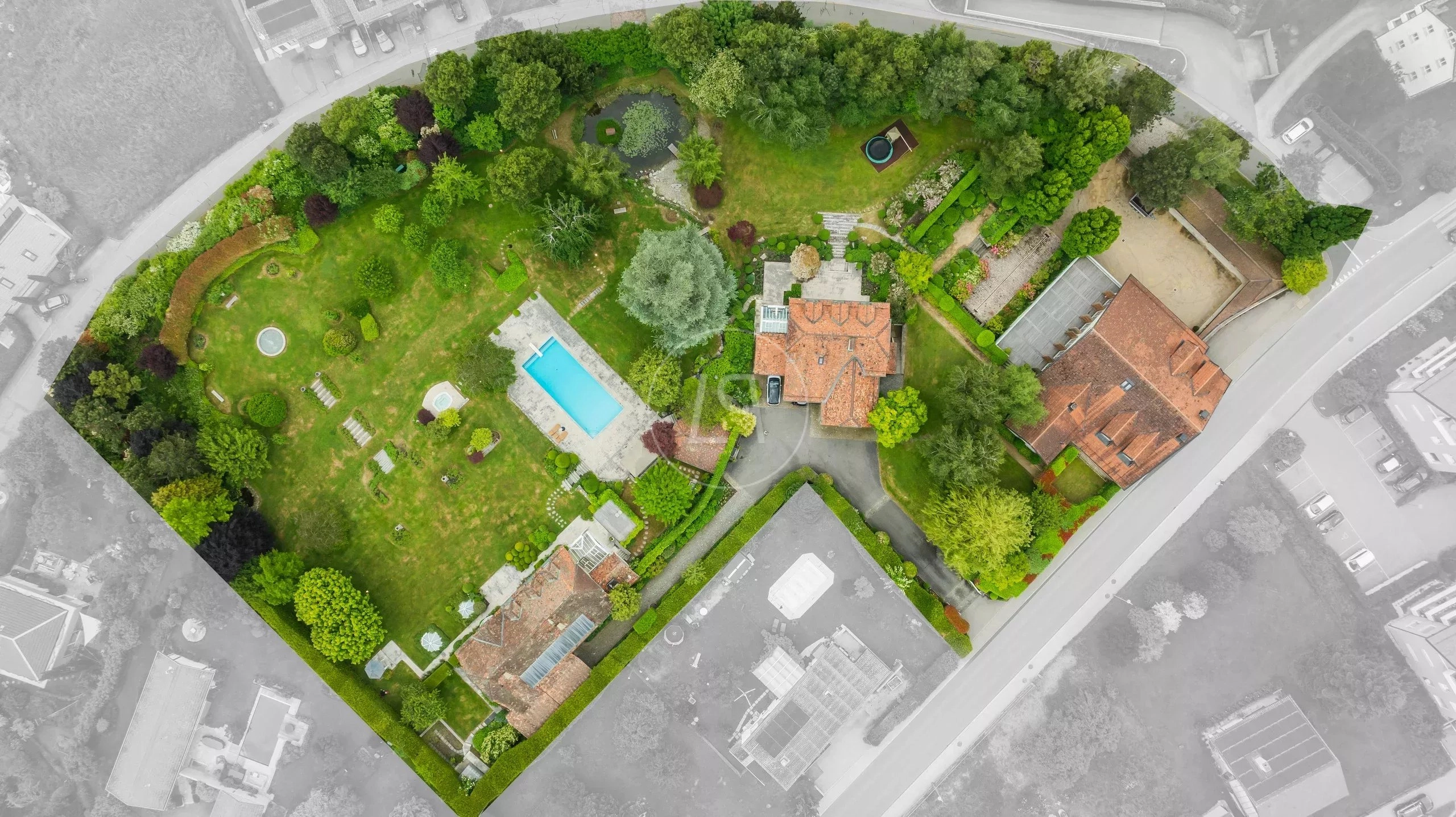 Luftbild eines großen Anwesens mit Garten, Pool und Nebengebäuden