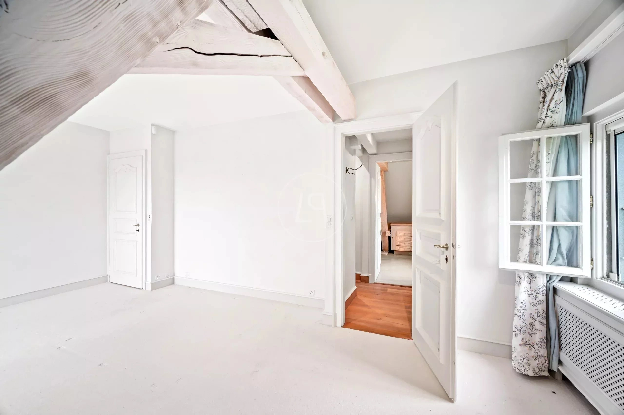 Helles Schlafzimmer mit sichtbaren Holzbalken